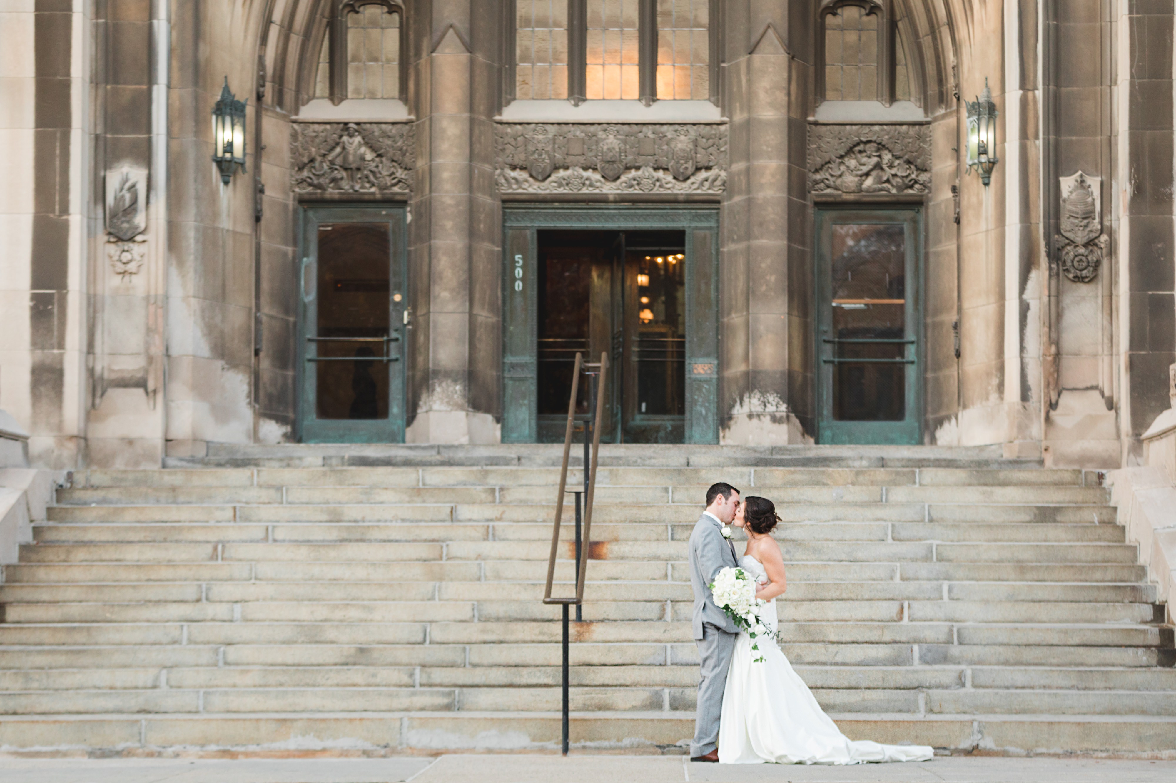 Bride and groom kissing on the steps of the Masonic Temple in Detroit. 