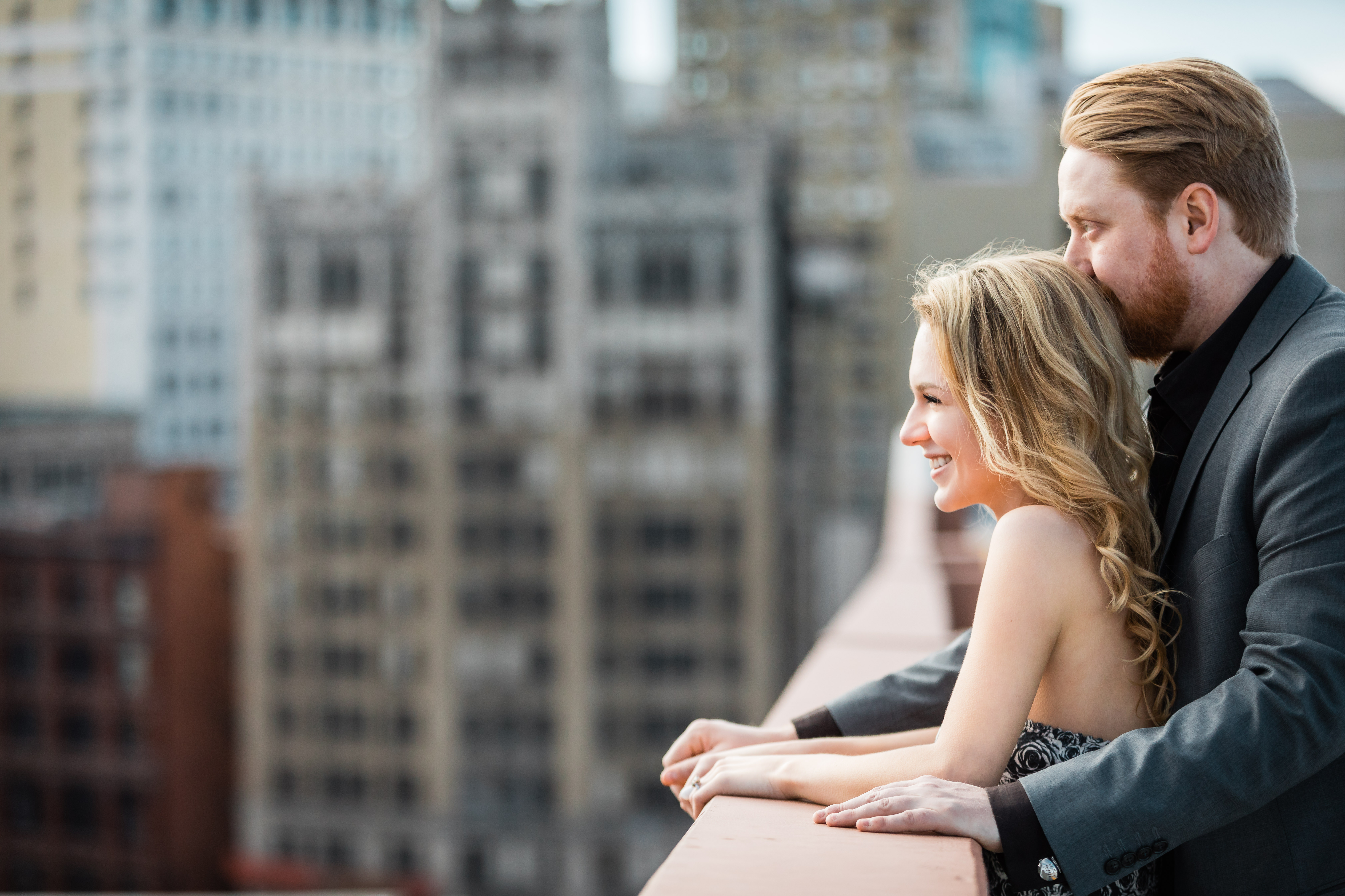 Couple standing on rooftop in Detroit overlooking the city