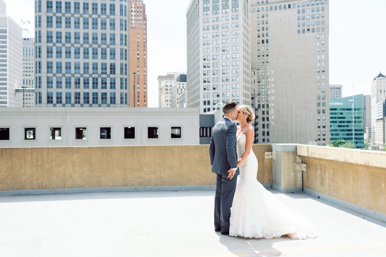 Bride and groom on the top of the parking structure kissing in Detroit Michigan