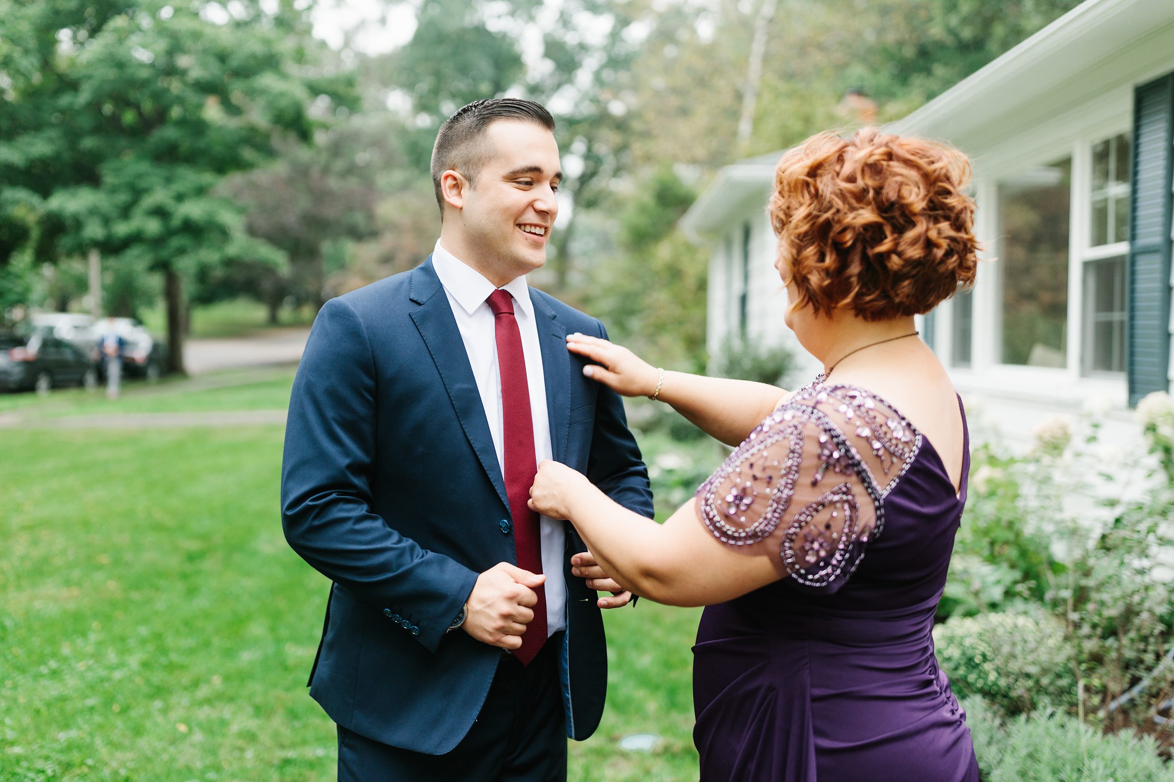 Mother of groom adjusts grooms suit outside for the Ann Arbor Intimate Wedding by Detroit Wedding Photographer Michele Maloney 