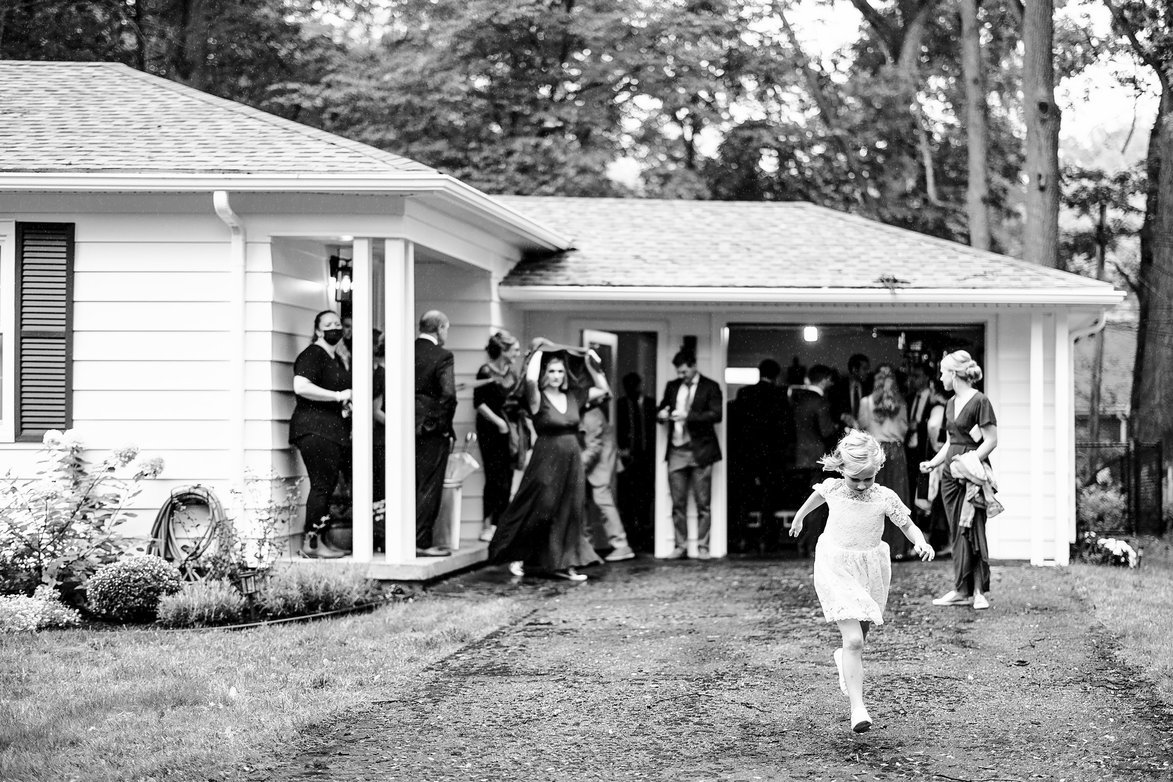 Black and white photo of guests and wedding party in the backyard of the Ann Arbor intimate wedding by Detroit Wedding Photographer Michele Maloney