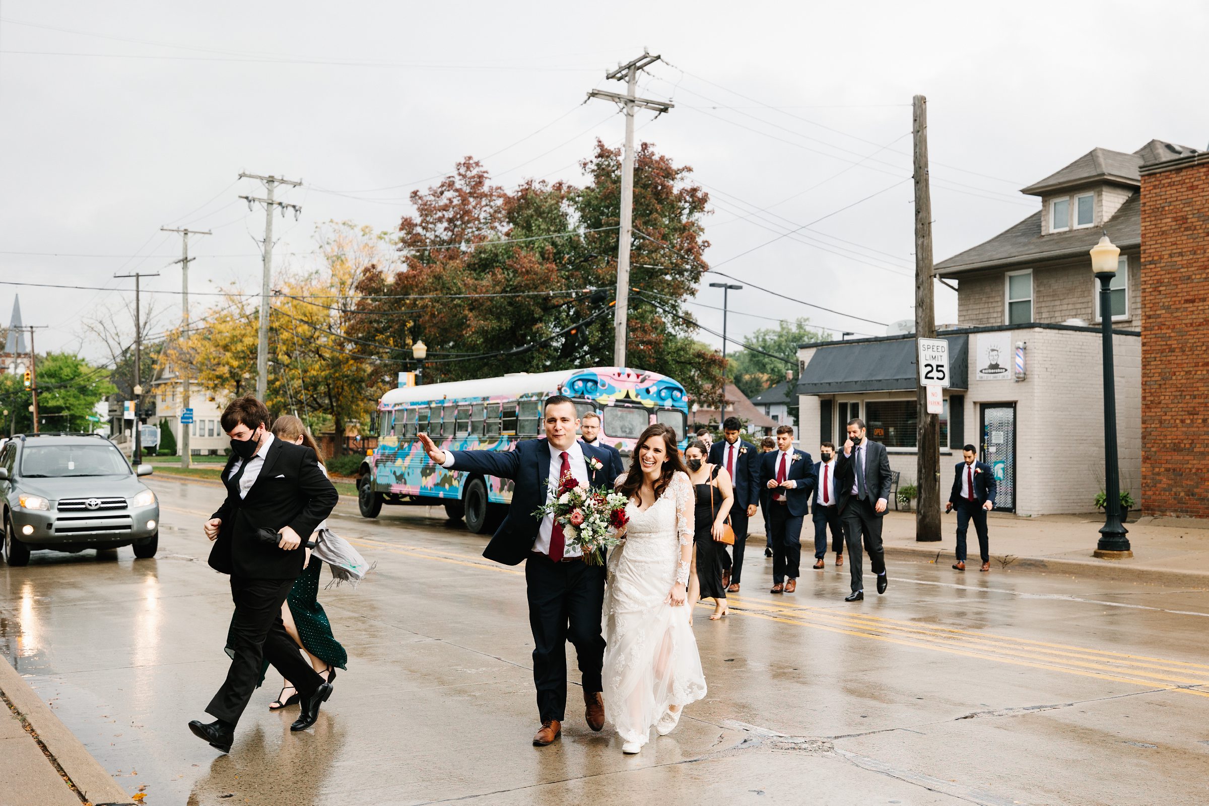 Bridal party is disembarking a party bus and walking across a street for their Ann Arbor Intimate Wedding by Detroit Wedding Photographer Michele Maloney