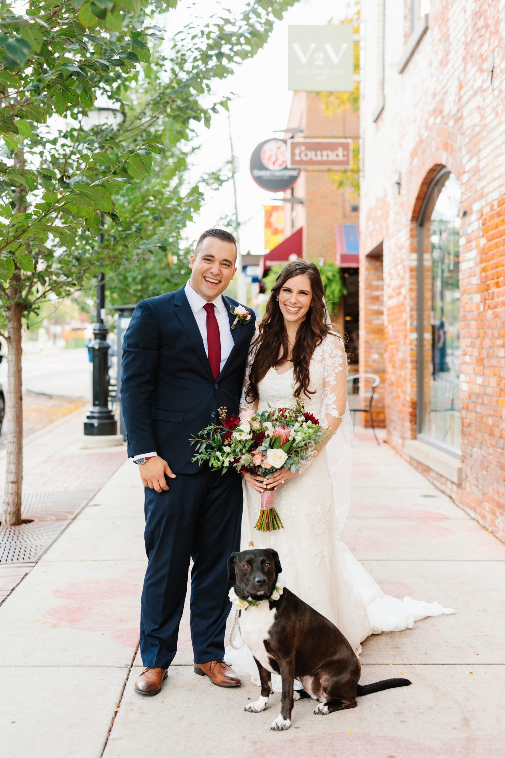 Bride and groom smile for an outside portrait with their dog front and center by Detroit Wedding Photographer Michele Maloney