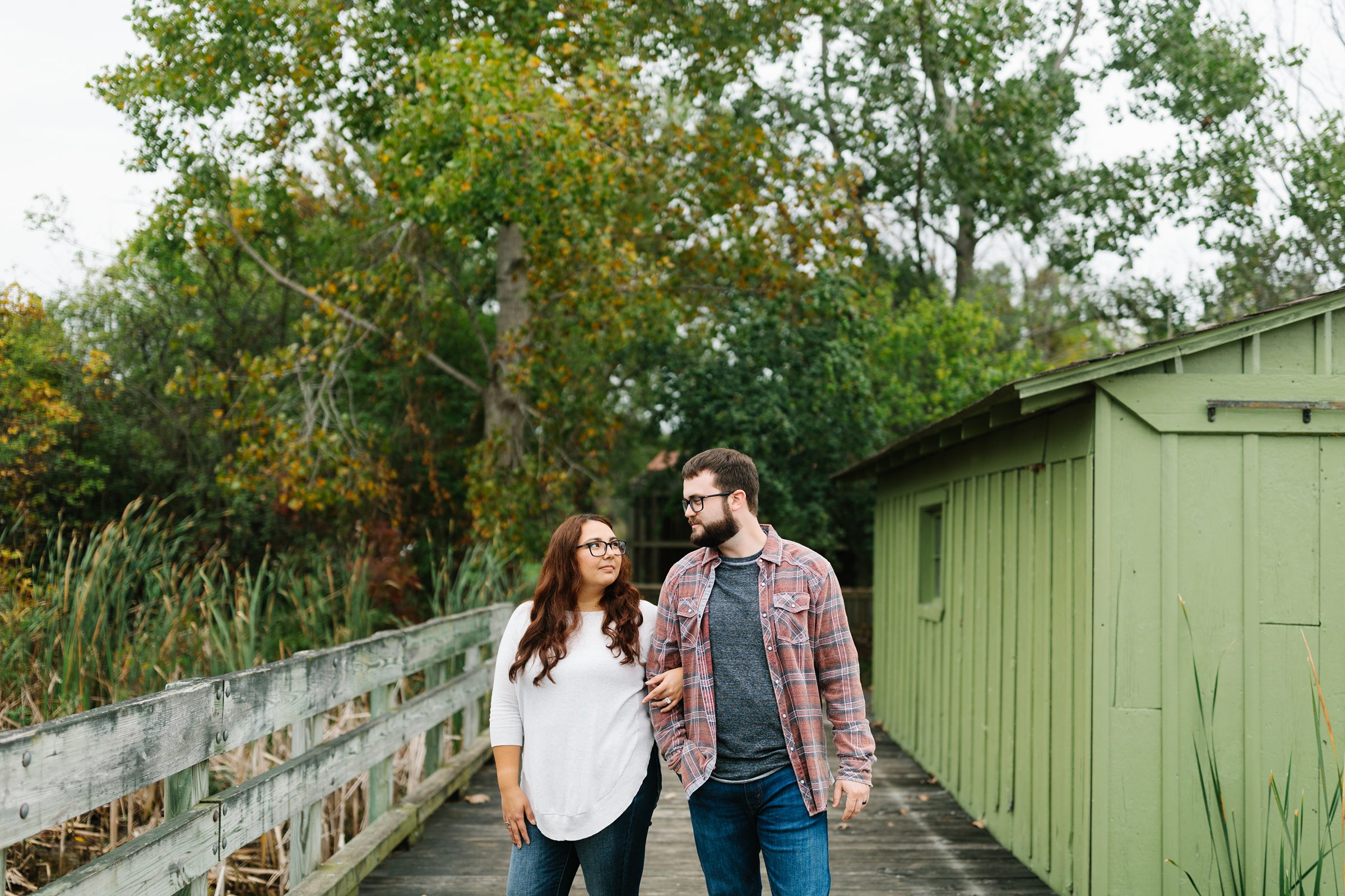 Engaged couple takes a stroll while looking at each other for a fall engagement session by Detroit Wedding Photographer Michele Maloney