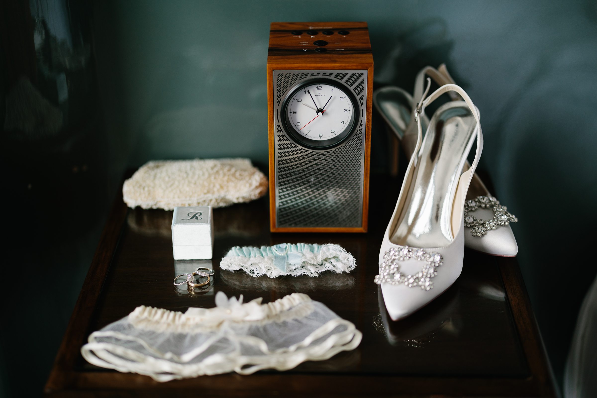 Detailed shot of the bride's shoes, rings, garter to keep and garter to toss, etc. by Detroit Wedding Photographer Michele Maloney
