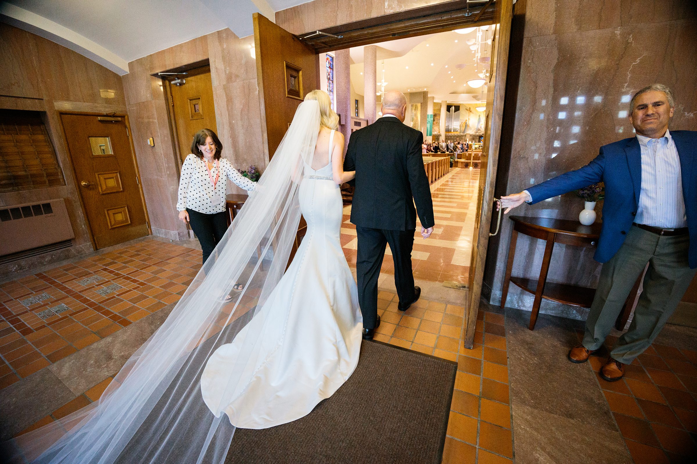 Shot from the back of bride and father of the bride about to walk down the aisle by Detroit Wedding Photographer Michele Maloney