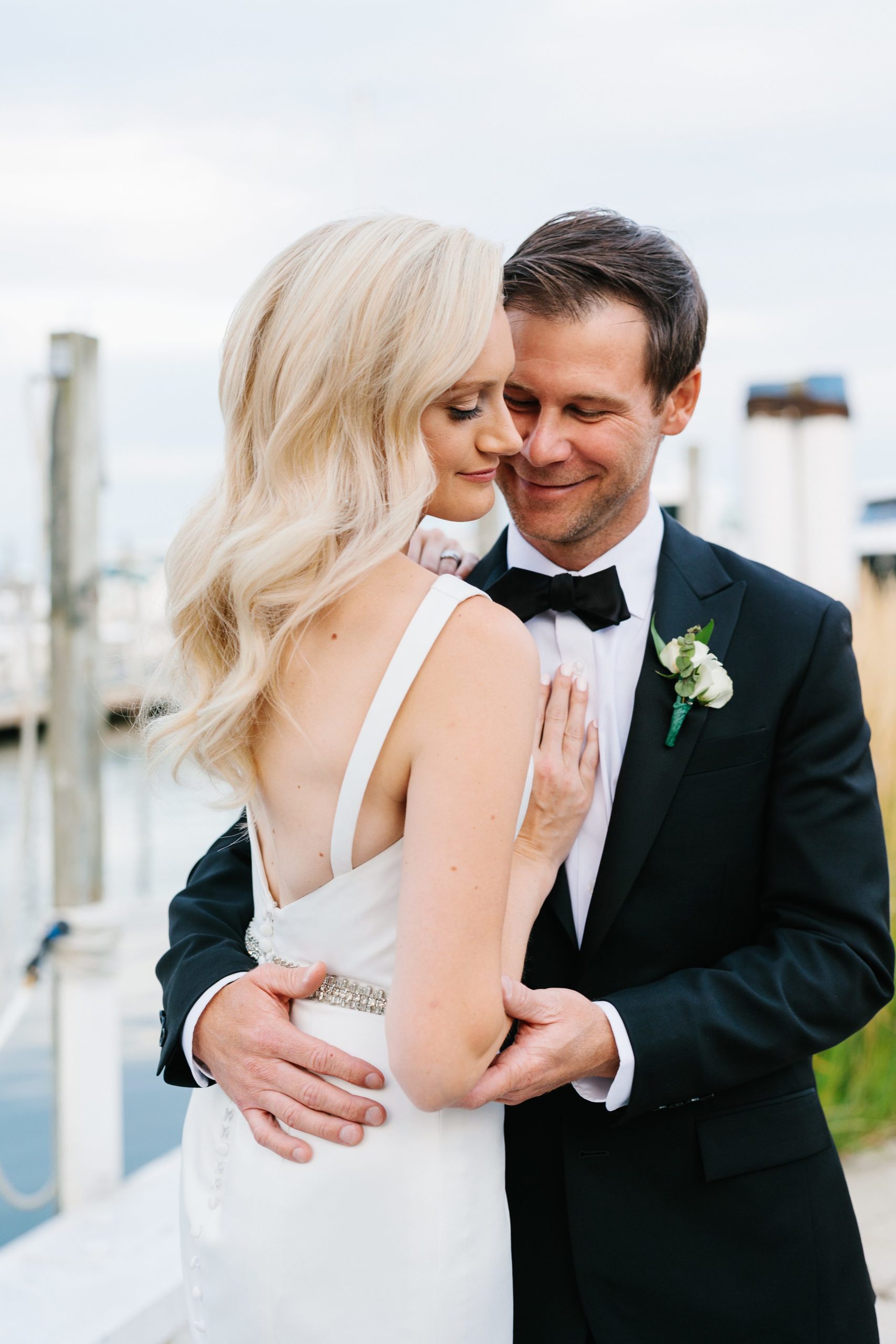 Bride and groom cozy up close for evening portraits at the Grosse Pointe Yacht Club by Detroit Wedding Photographer Michele Maloney