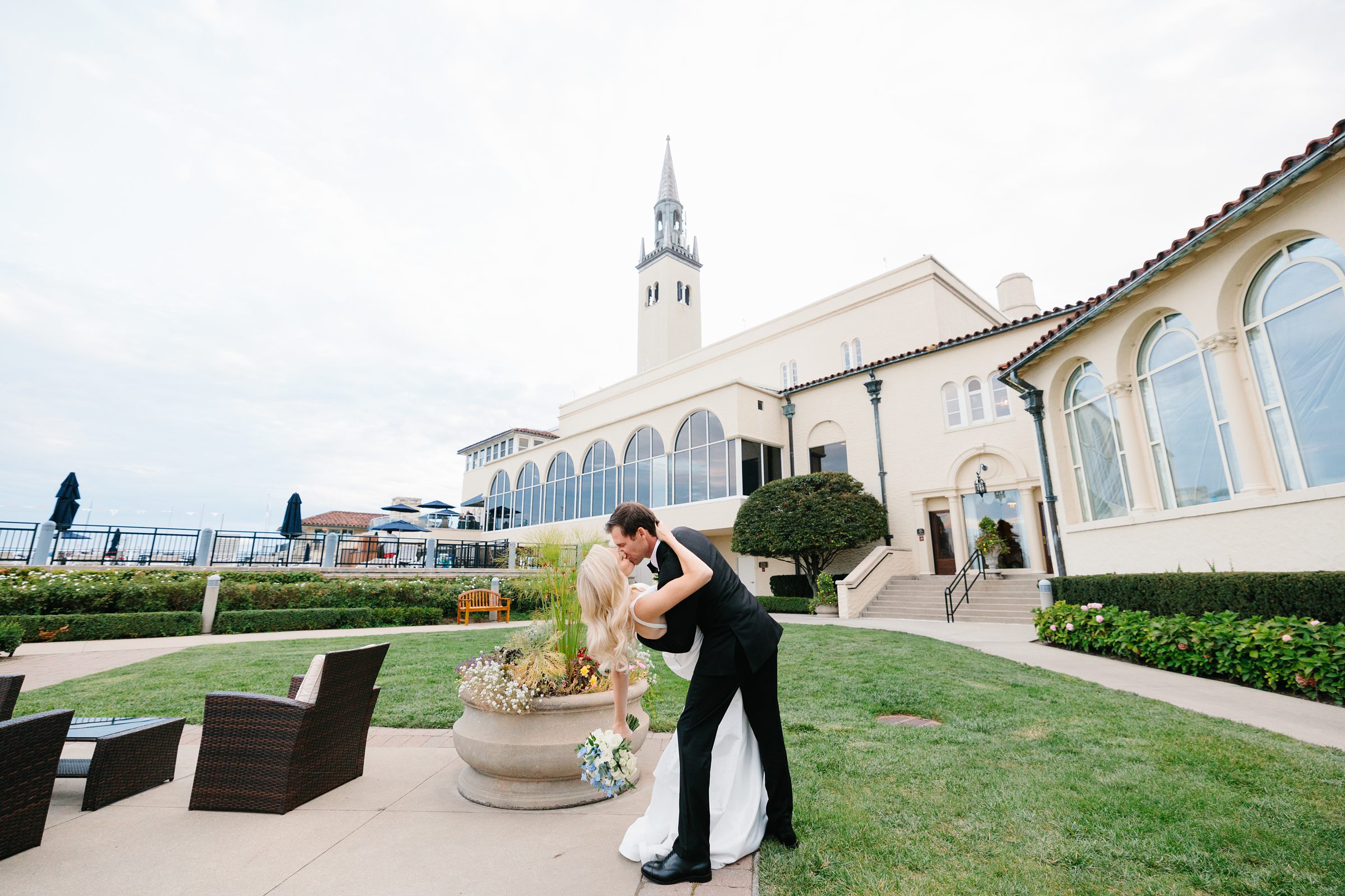 Groom dips his bride as they kiss at the Grosse Pointe Yacht Club by Detroit Wedding Photographer Michele Maloney
