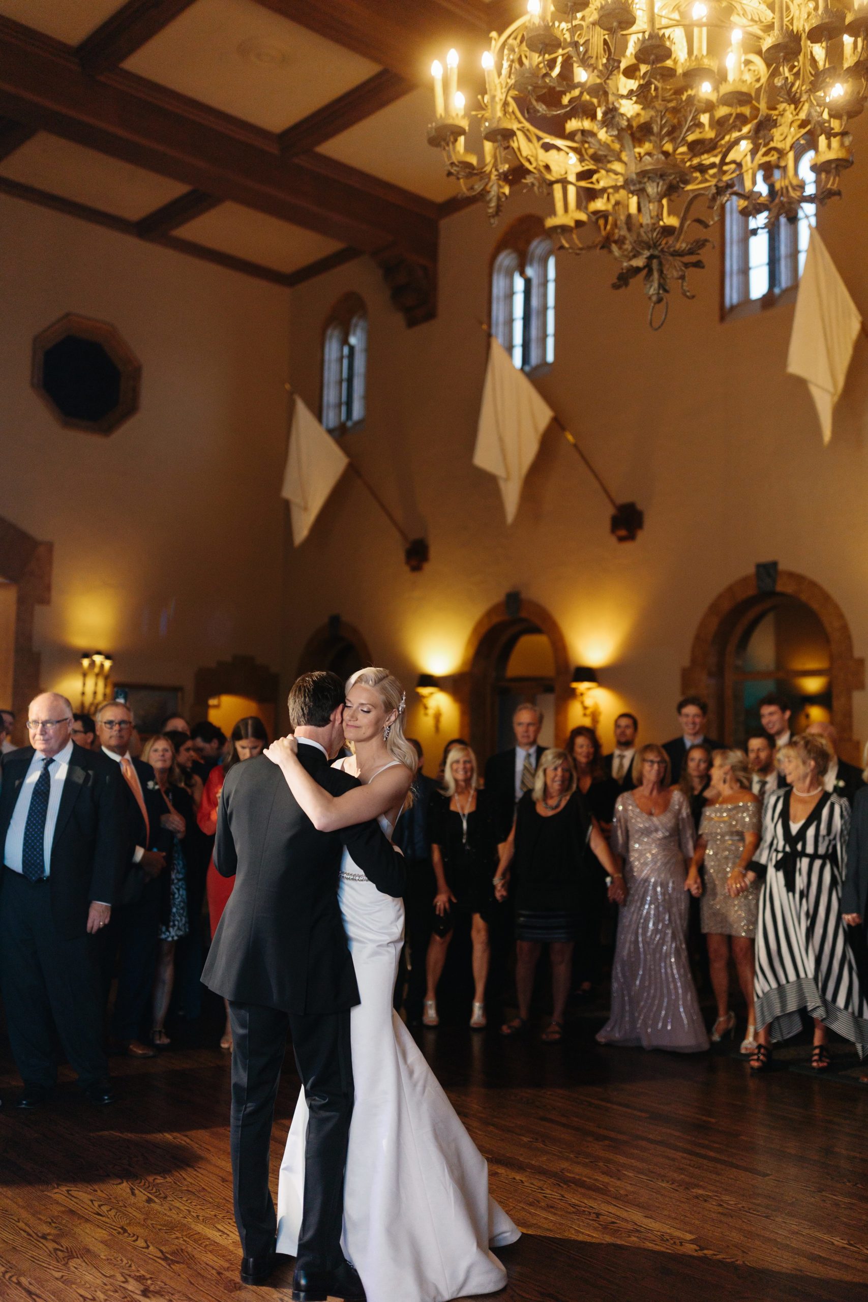 Bride and groom cozy up close while guests watch them slow dance at the Grosse Pointe Yacht Club by Detroit Wedding Photographer Michele Maloney