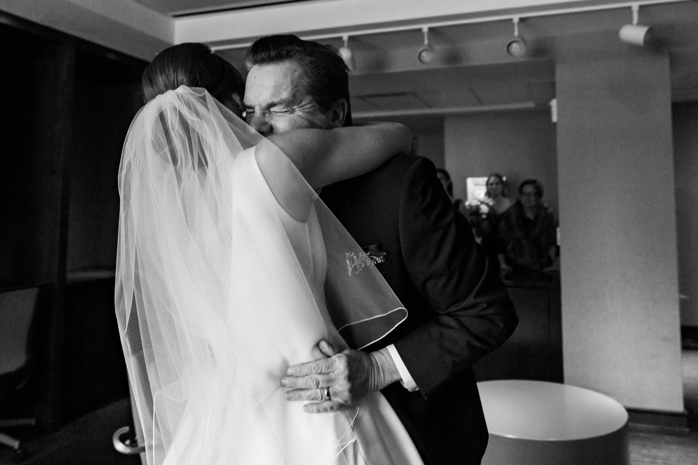 Black and white photo of bride and father hugging by Detroit Wedding Photographer Michele Maloney