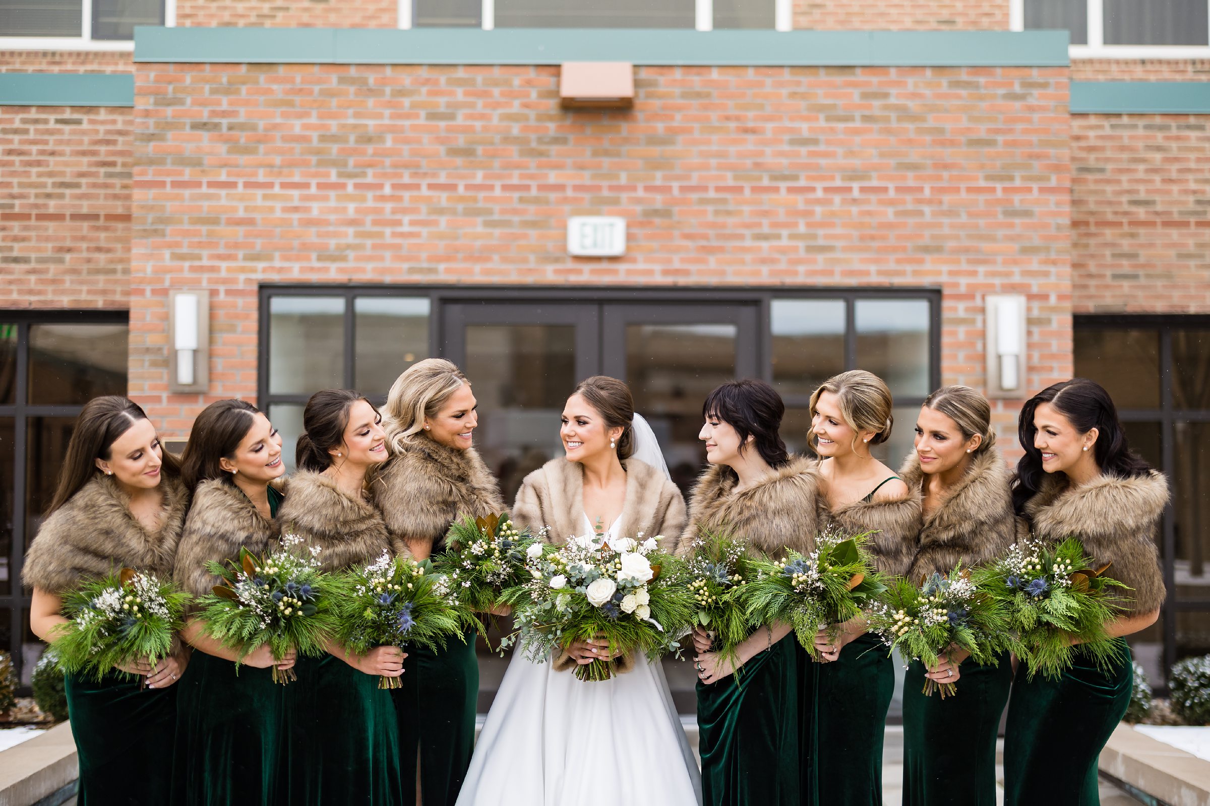 bride and bridesmaids take formal wedding party photos outside in the chilly air holding bouquets by Detroit Wedding Photographer Michele Maloney 