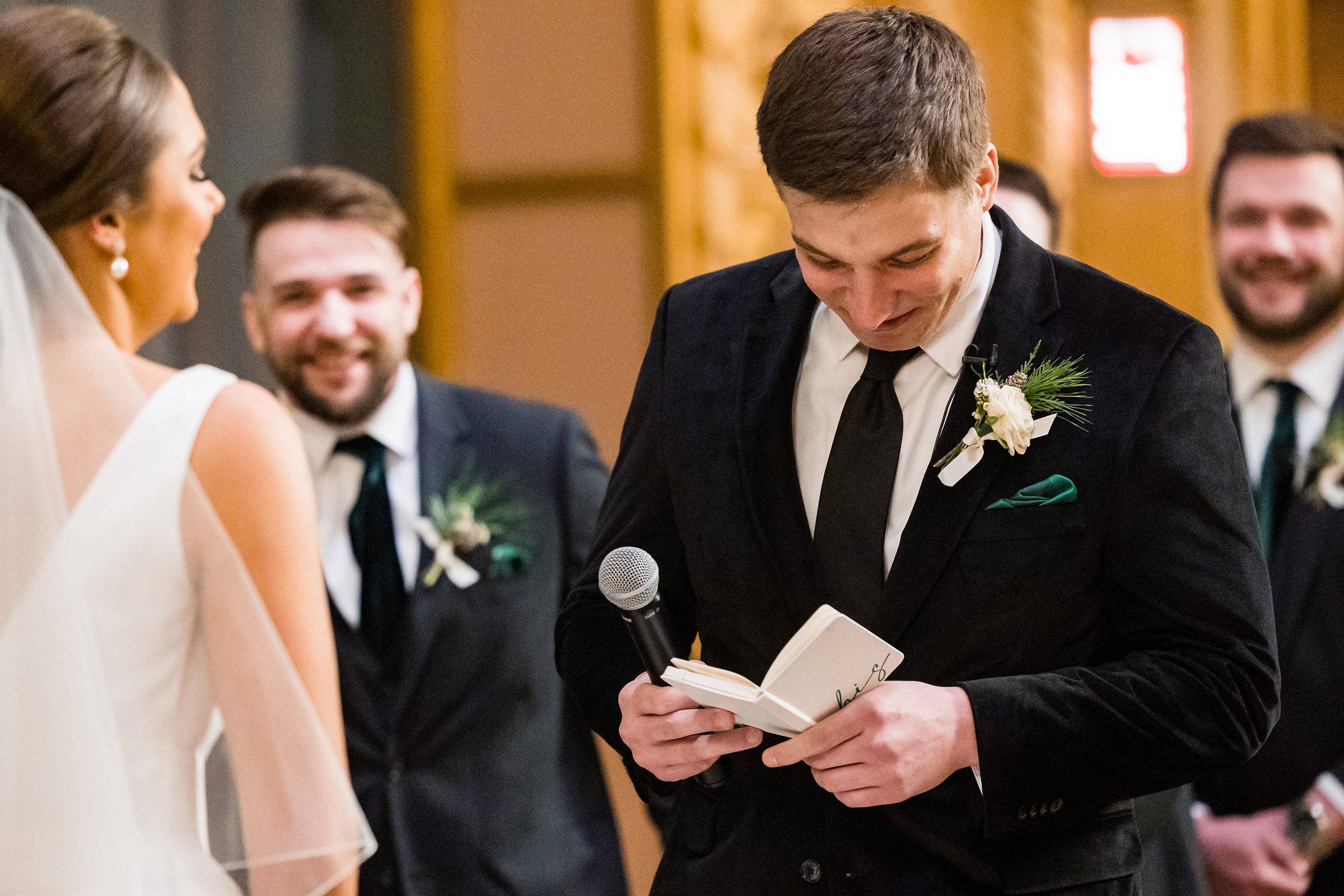Groom smiles while reading his vows to his bride by Detroit Wedding Photographer Michele Maloney