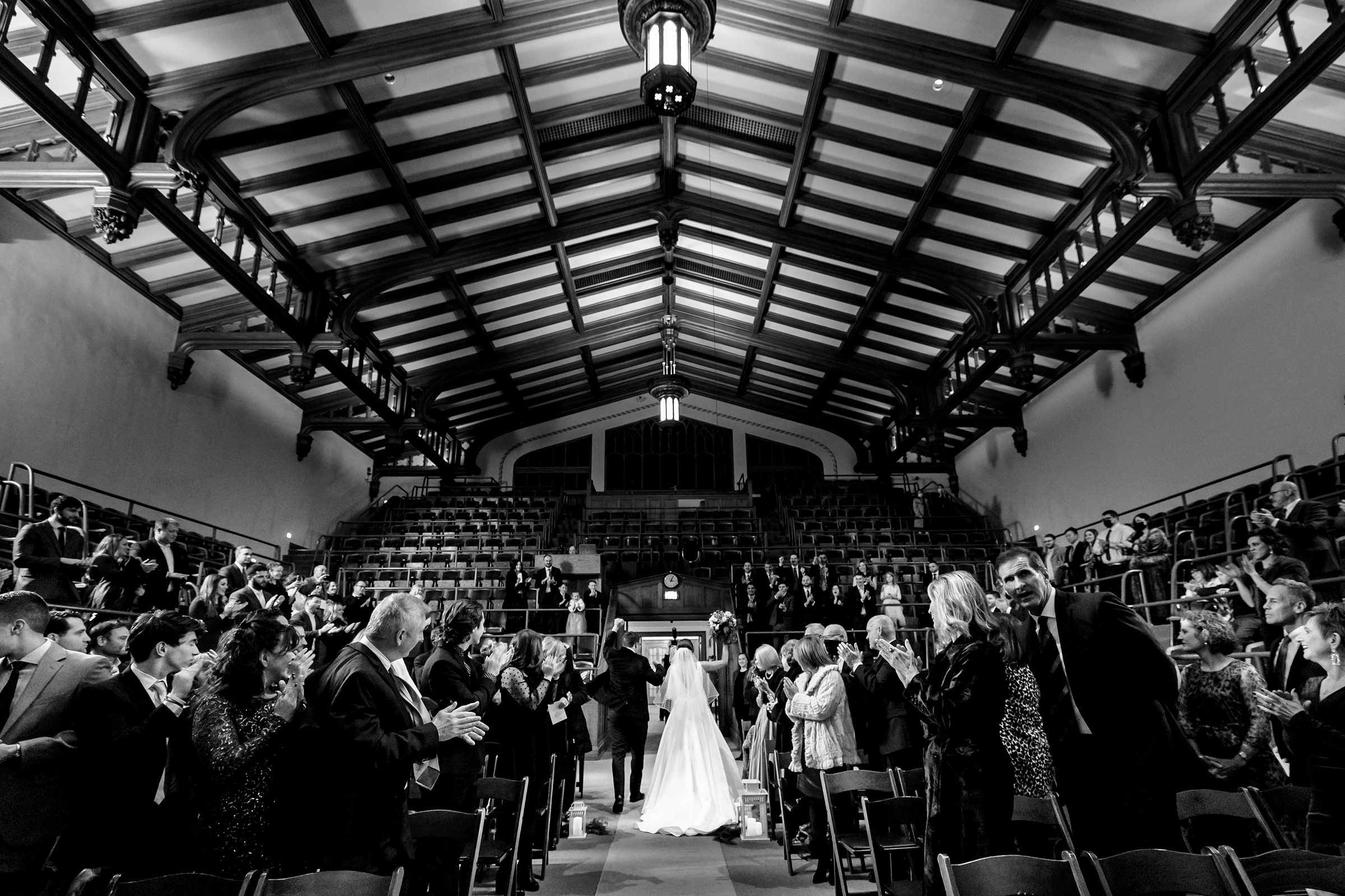 Black and white photo of the back of the bride and groom as they exit the ceremony by Detroit Wedding Photographer Michele Maloney