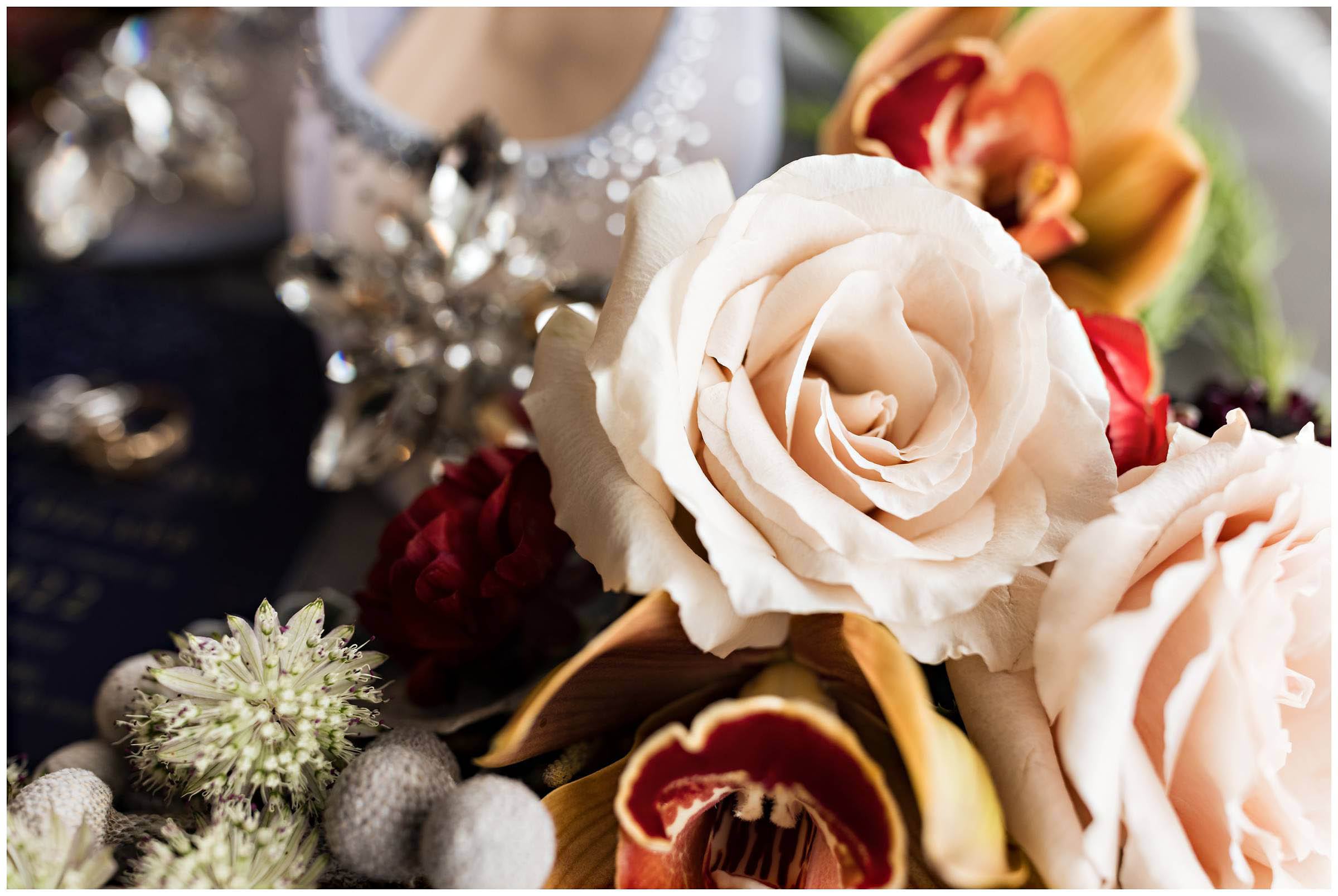 Closeup of wedding bouquet with bride's shoes in the background by Detroit Wedding Photographer Michele Maloney