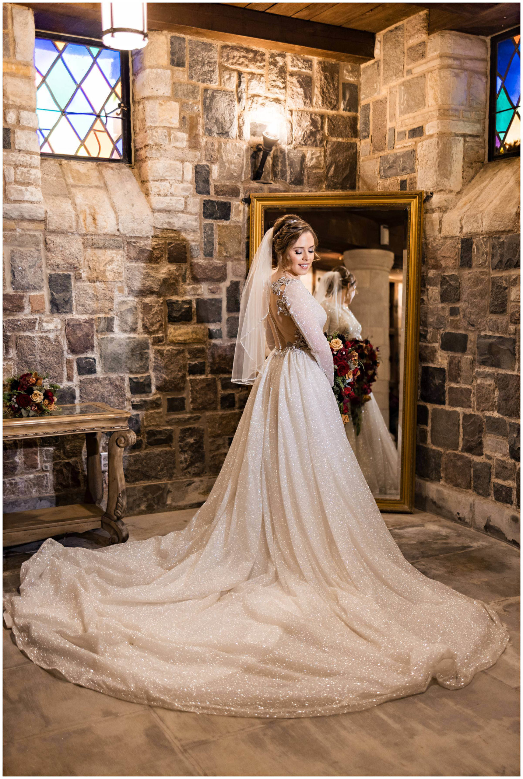 Full shot of bride's wedding dress with the bride looking down and smiling, holding bouquet with mirror behind her by Detroit Wedding Photographer Michele Maloney