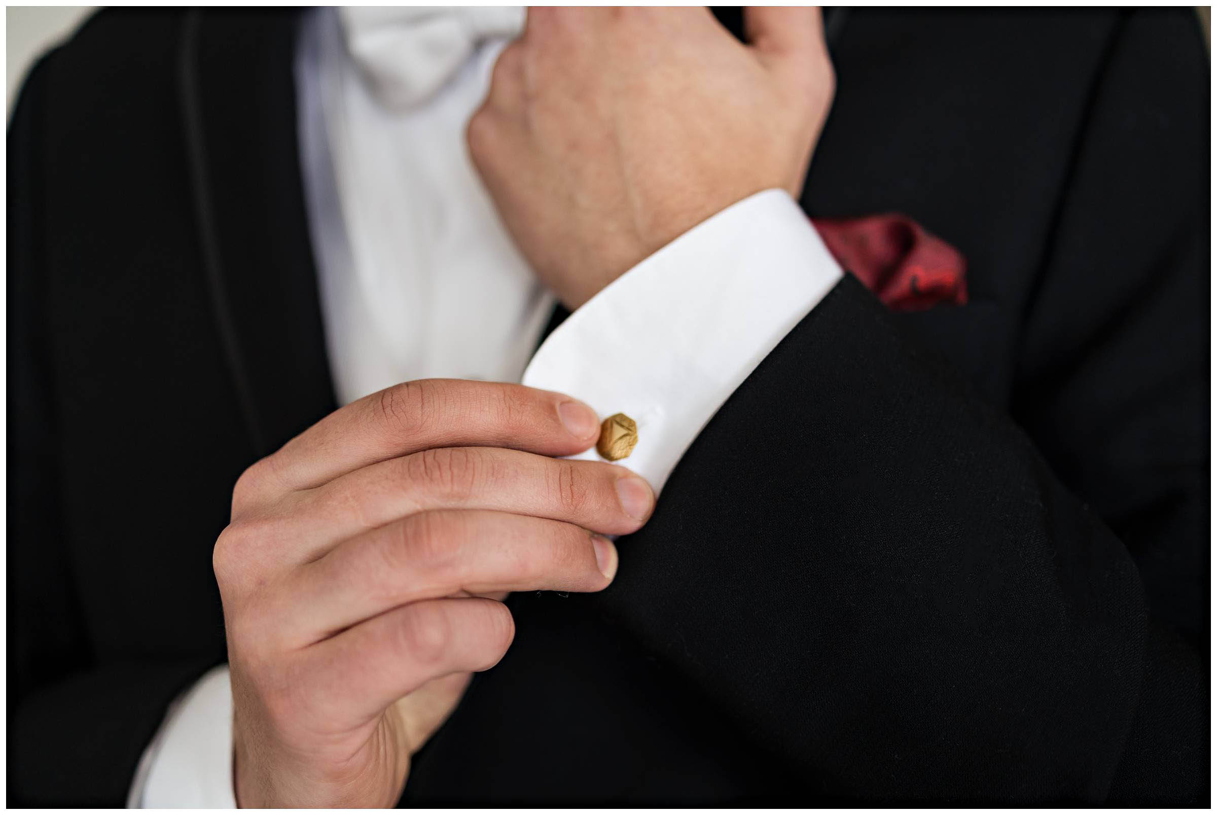 Closeup of groom's hands adjusting his cuff links by Detroit Wedding Photographer Michele Maloney