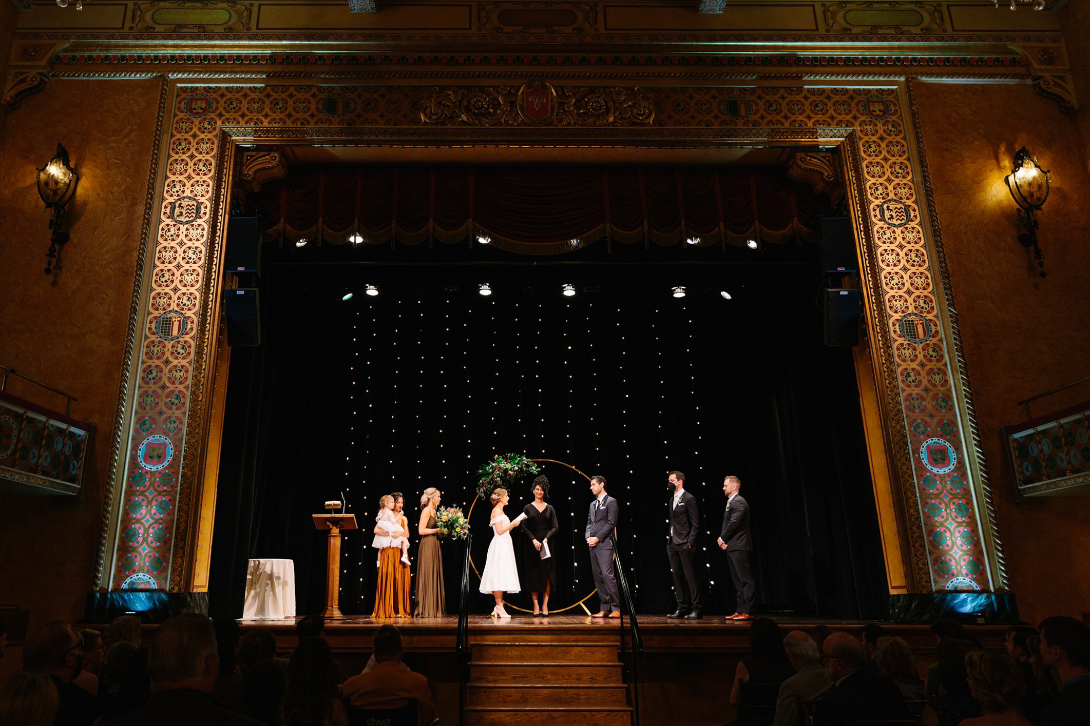 Bride and Groom exchange Wedding Vows at a ceremony on stage at the Gem Theatre in Detroit by Detroit Wedding Photographer Michele Maloney