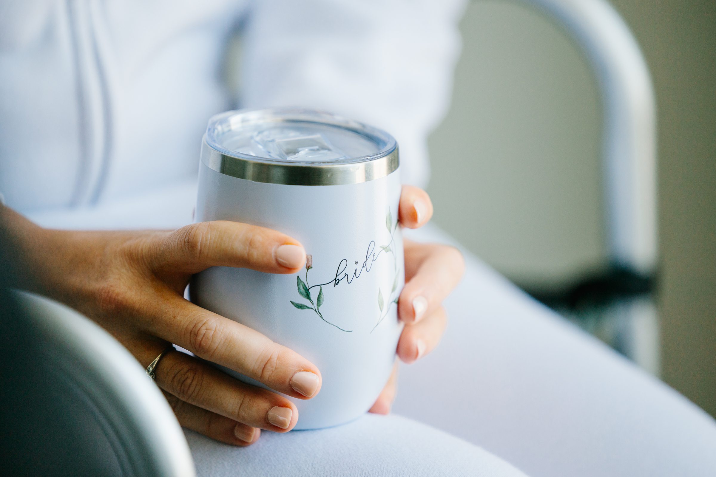 Bride holds her special bride thermos in her lap while she gets ready by Detroit Wedding Photographer Michele Maloney 