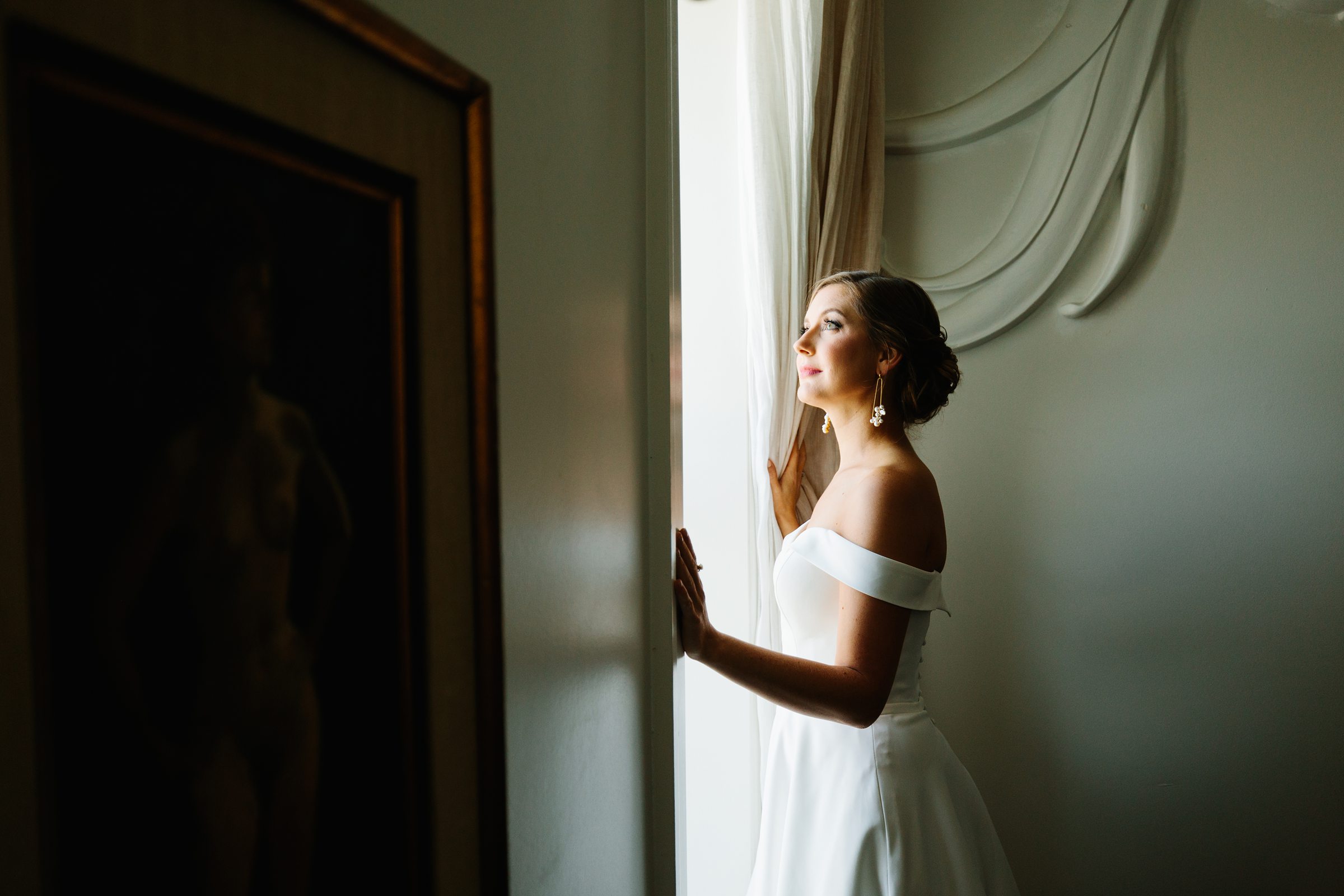 Portrait of the bride looking out the window of the Siren Hotel by Detroit Wedding Photographer Michele Maloney