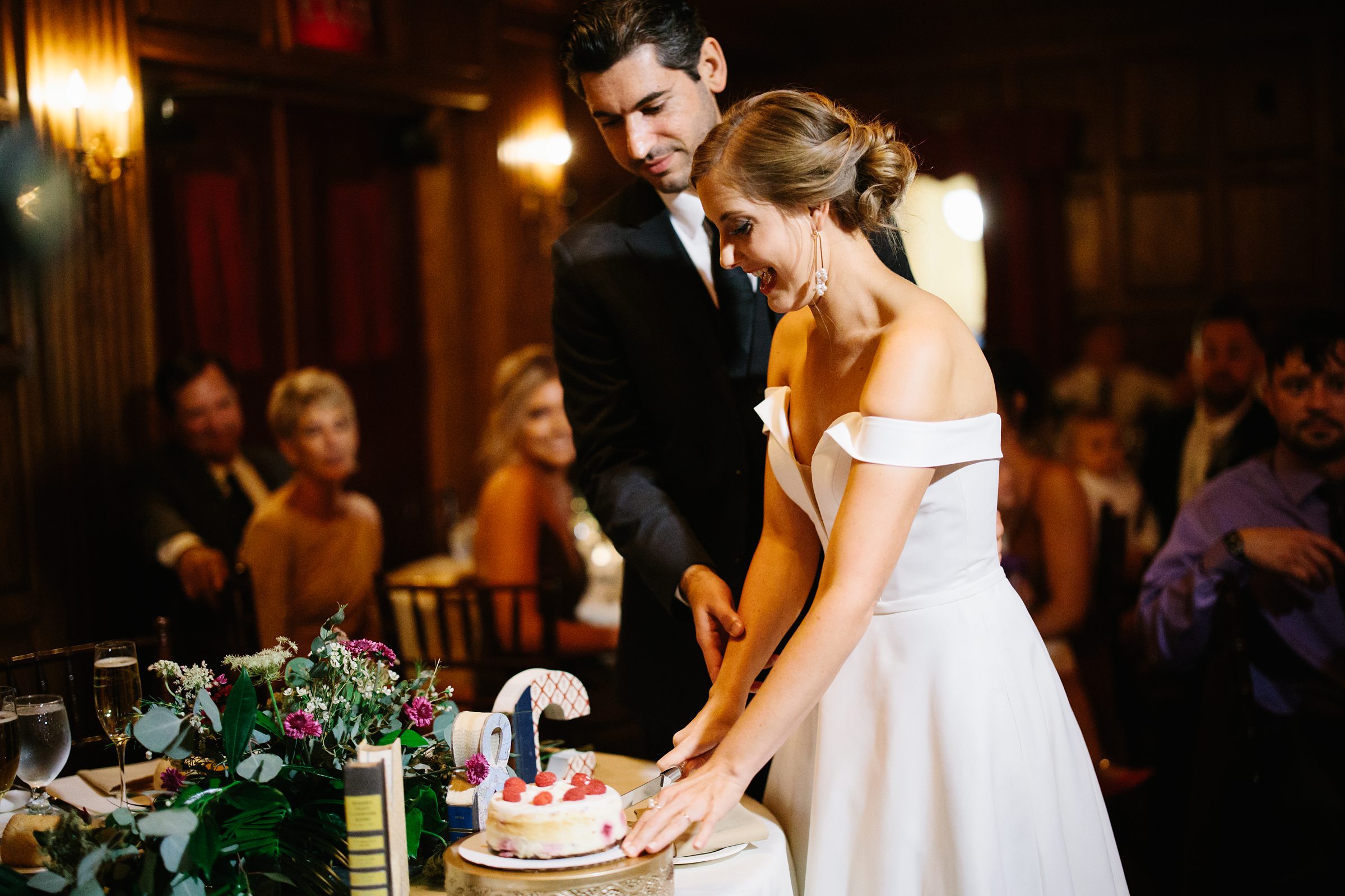 bride and groom cut the cake at a reception at the Gem Theatre in Detroit by Detroit Wedding Photographer Michele Maloney