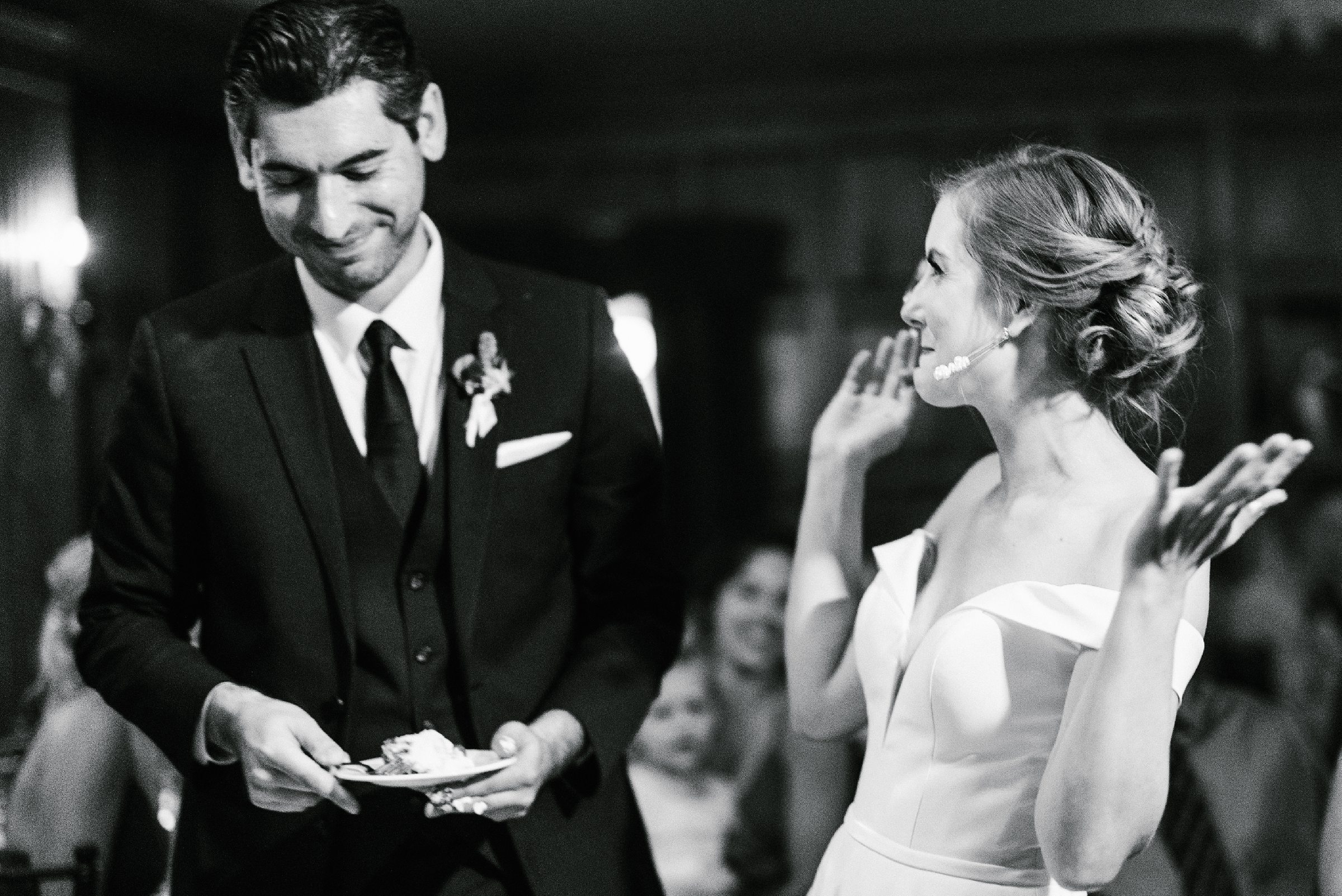 Black and white photo of the bride and groom enjoying the first slice of their cake by Detroit Wedding Photographer Michele Maloney