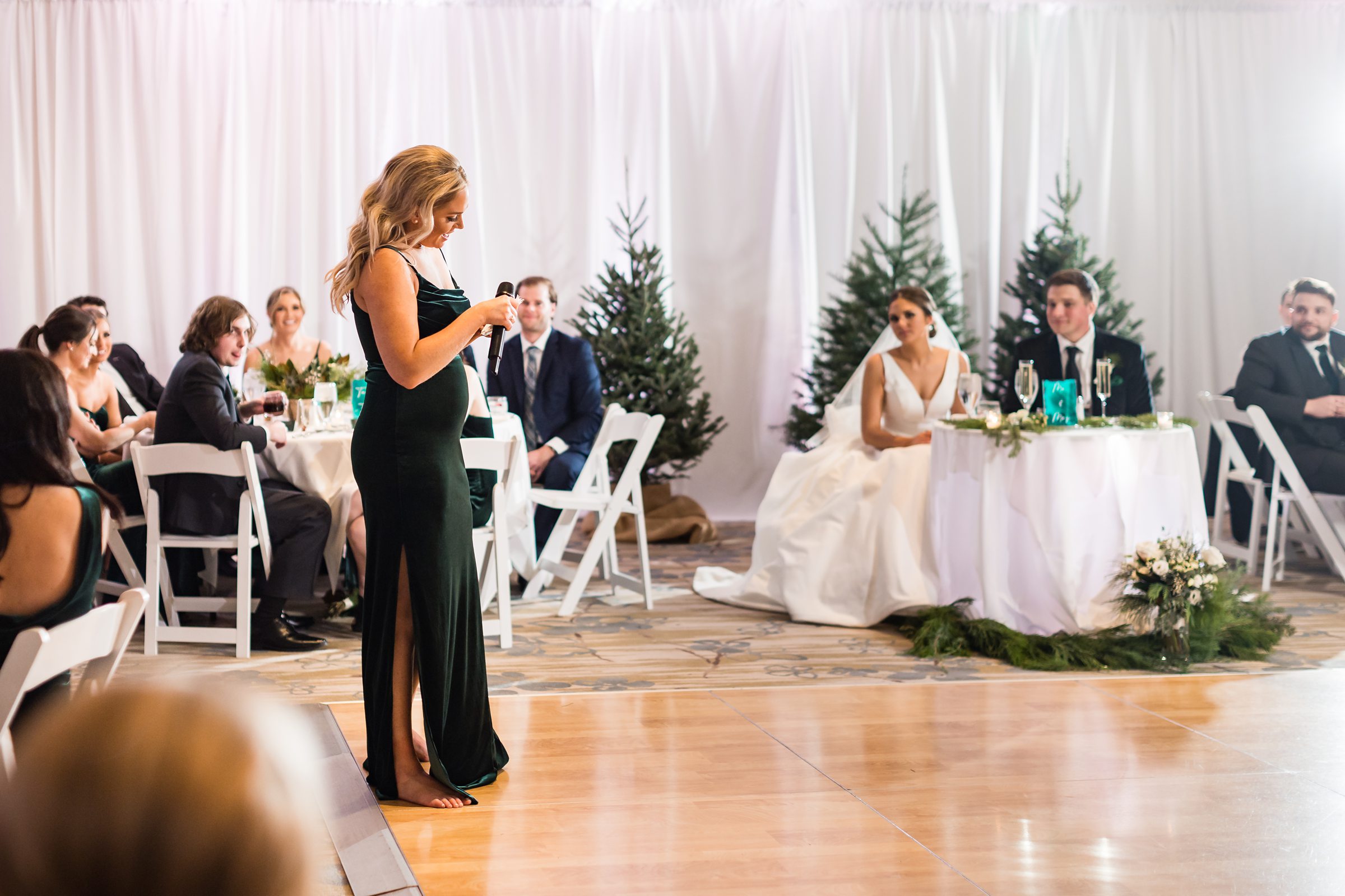 Bride, groom, and guests listen to a bridesmaid's wedding toast by Detroit Wedding Photographer Michele Maloney