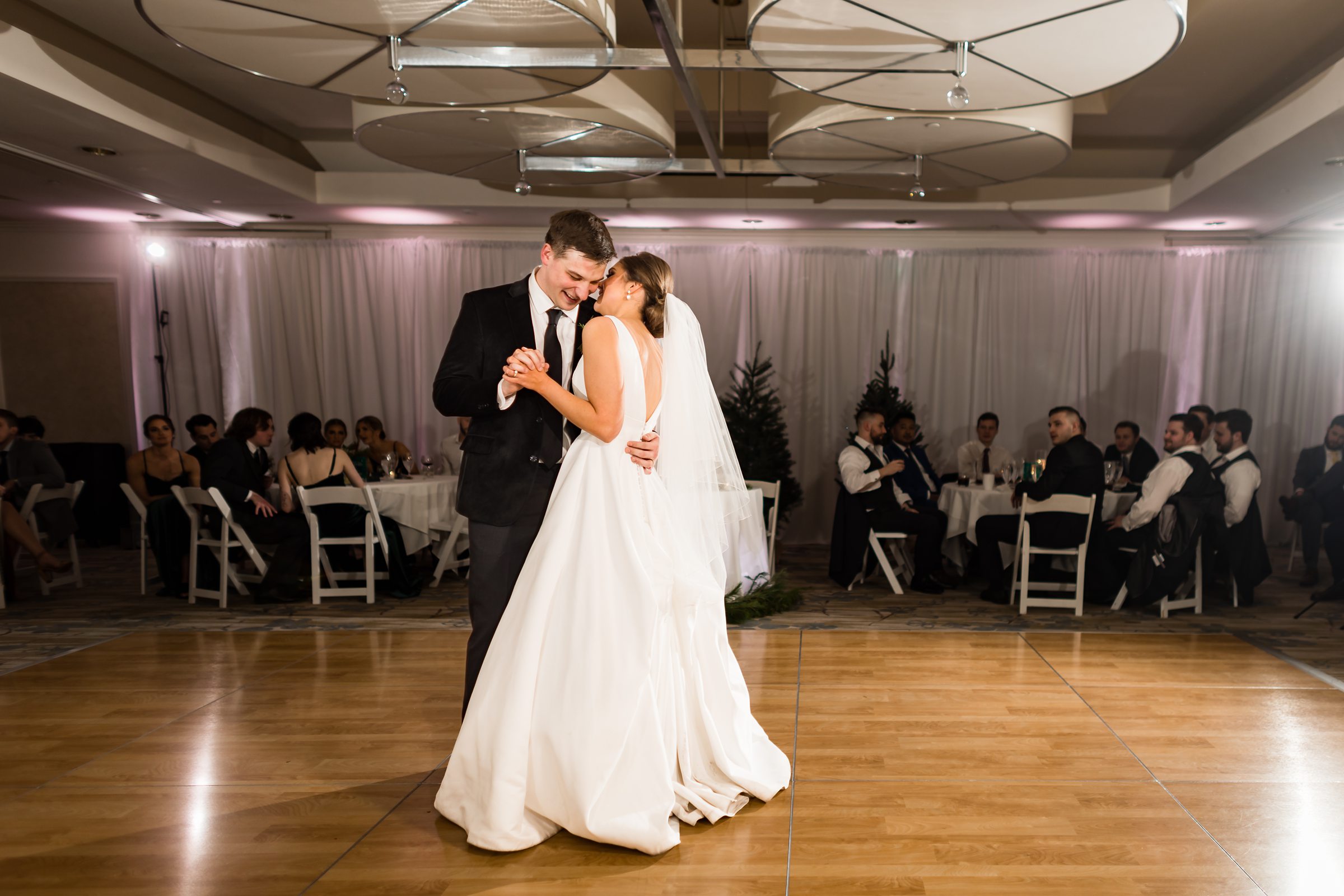 Bride and groom cozy up for their first dance while guests watch by Detroit Wedding Photographer Michele Maloney
