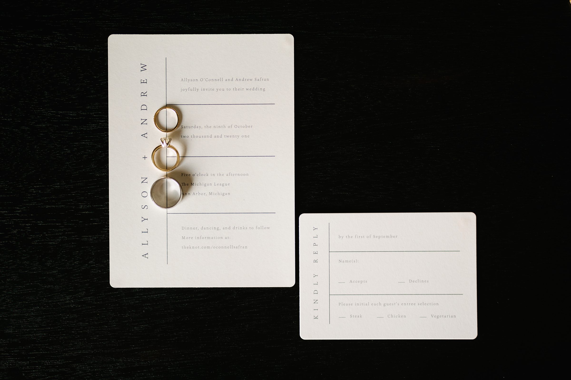 Detailed shot of the wedding invitation along with the bride and groom's rings by Detroit Wedding Photographer Michele Maloney