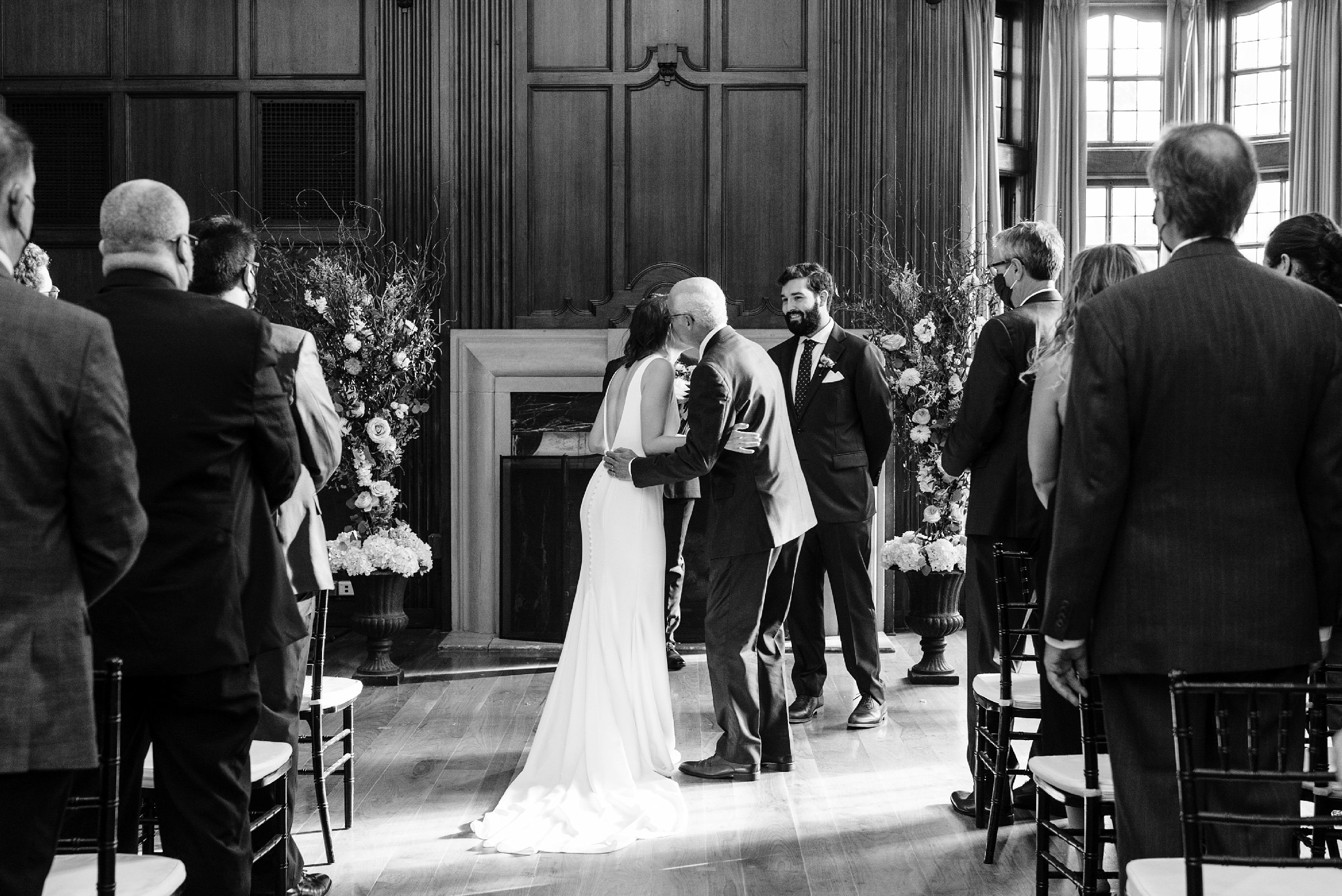 Black and white photo of the father of the bride kissing the bride and giving her away by Detroit Wedding Photographer Michele Maloney 