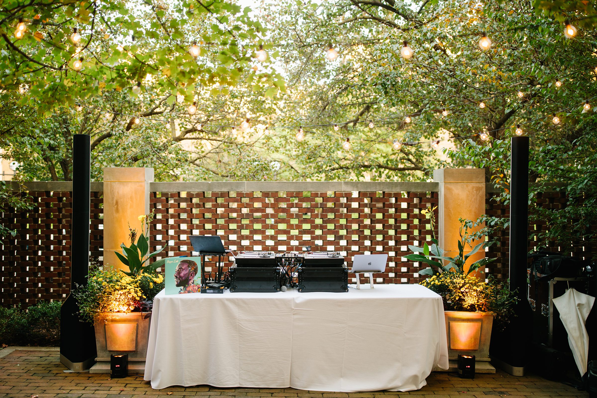 The DJ's outdoor setup sits under trees and cafe lights for The Inn at the Michigan League Wedding reception by Detroit Wedding Photographer Michele Maloney