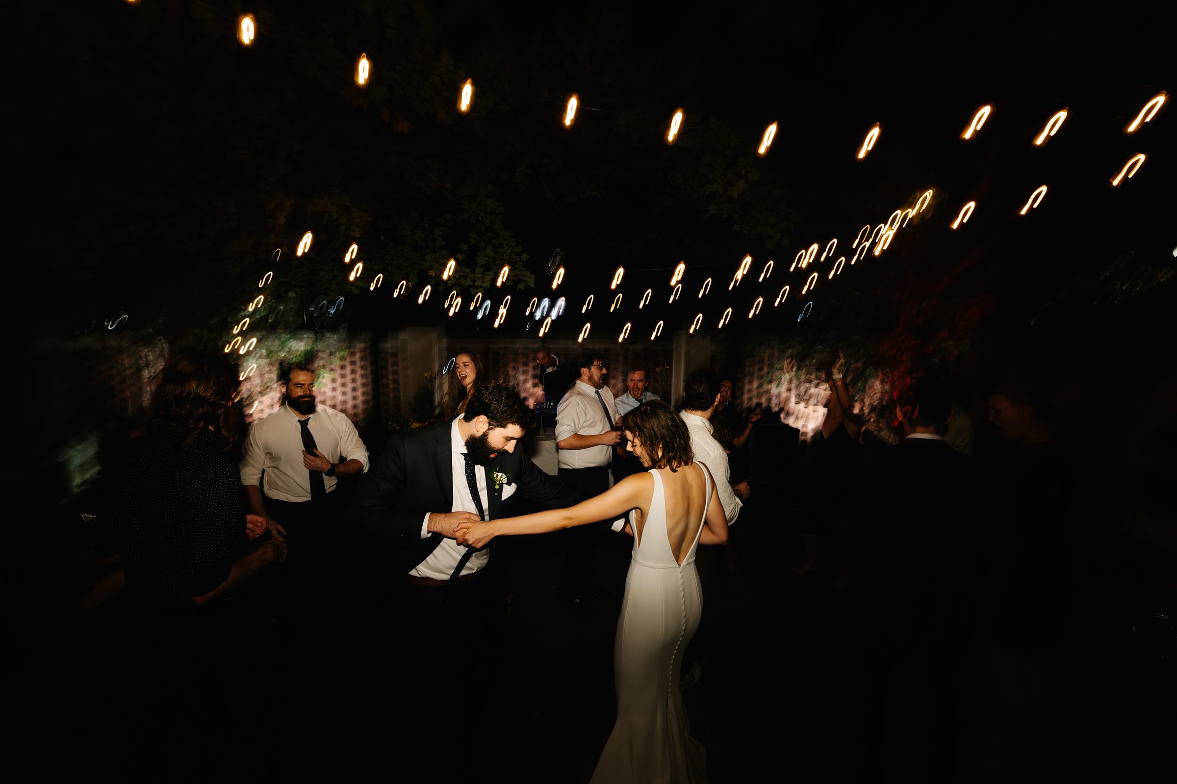 Bride and groom enjoy a dance at night under blurred lights for their reception at The Inn at the Michigan League by Detroit Wedding Photographer Michele Maloney 
