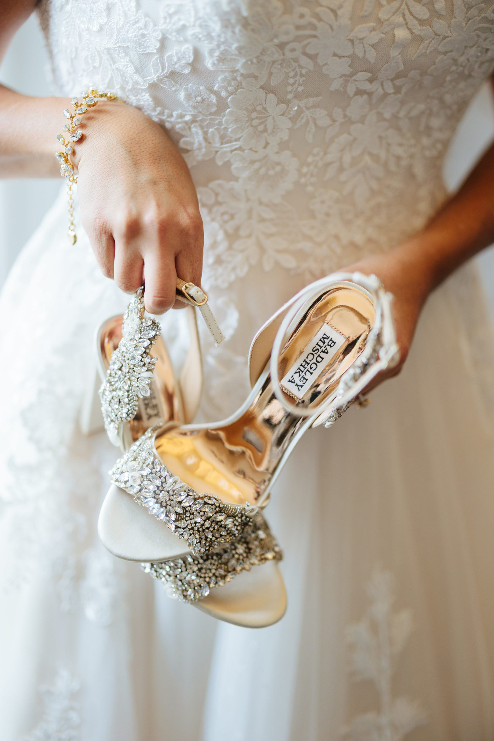 Bride holding shoes getting ready at her wedding at the Inn at St. Johns by Michele Maloney Photography