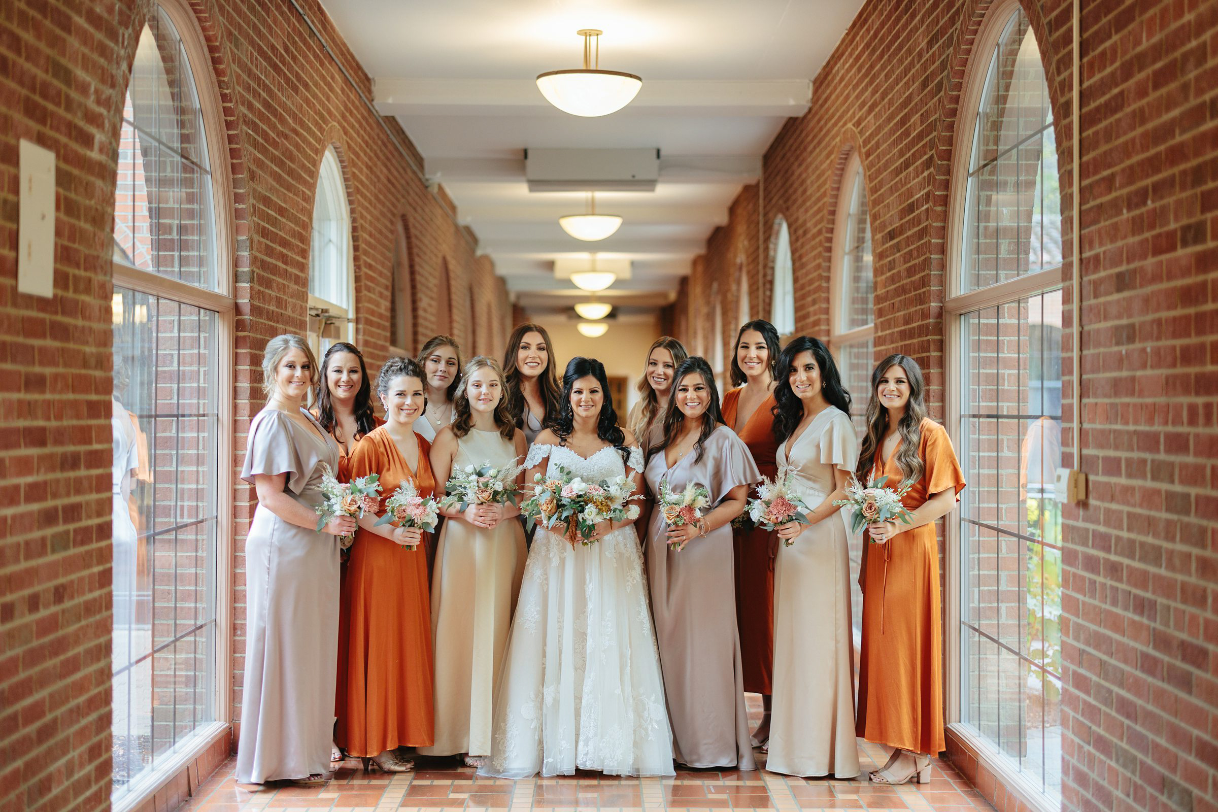 bride and her bridesmaids in the hall at the Inn at St. Johns in Plymouth Michigan by Michele Maloney Photography