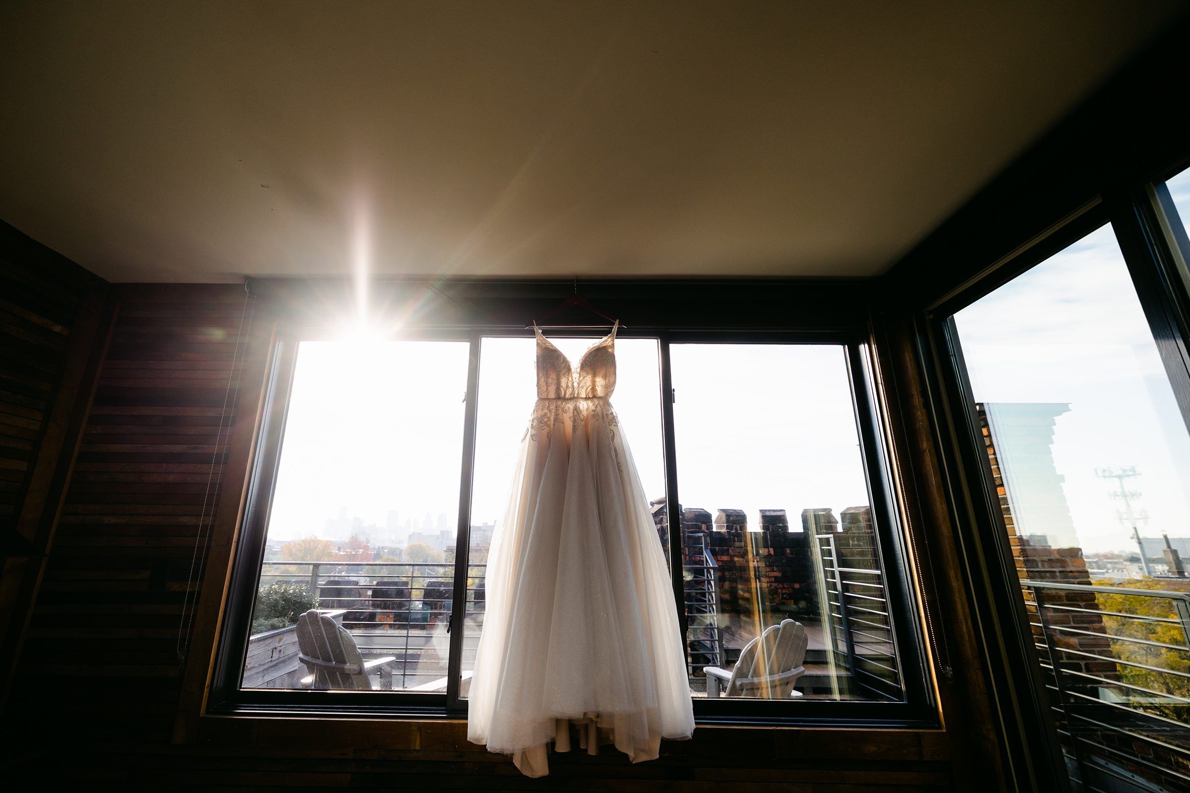 Wedding Dress in the window overlooking Detroit's Skyline by Michele Maloney Photography