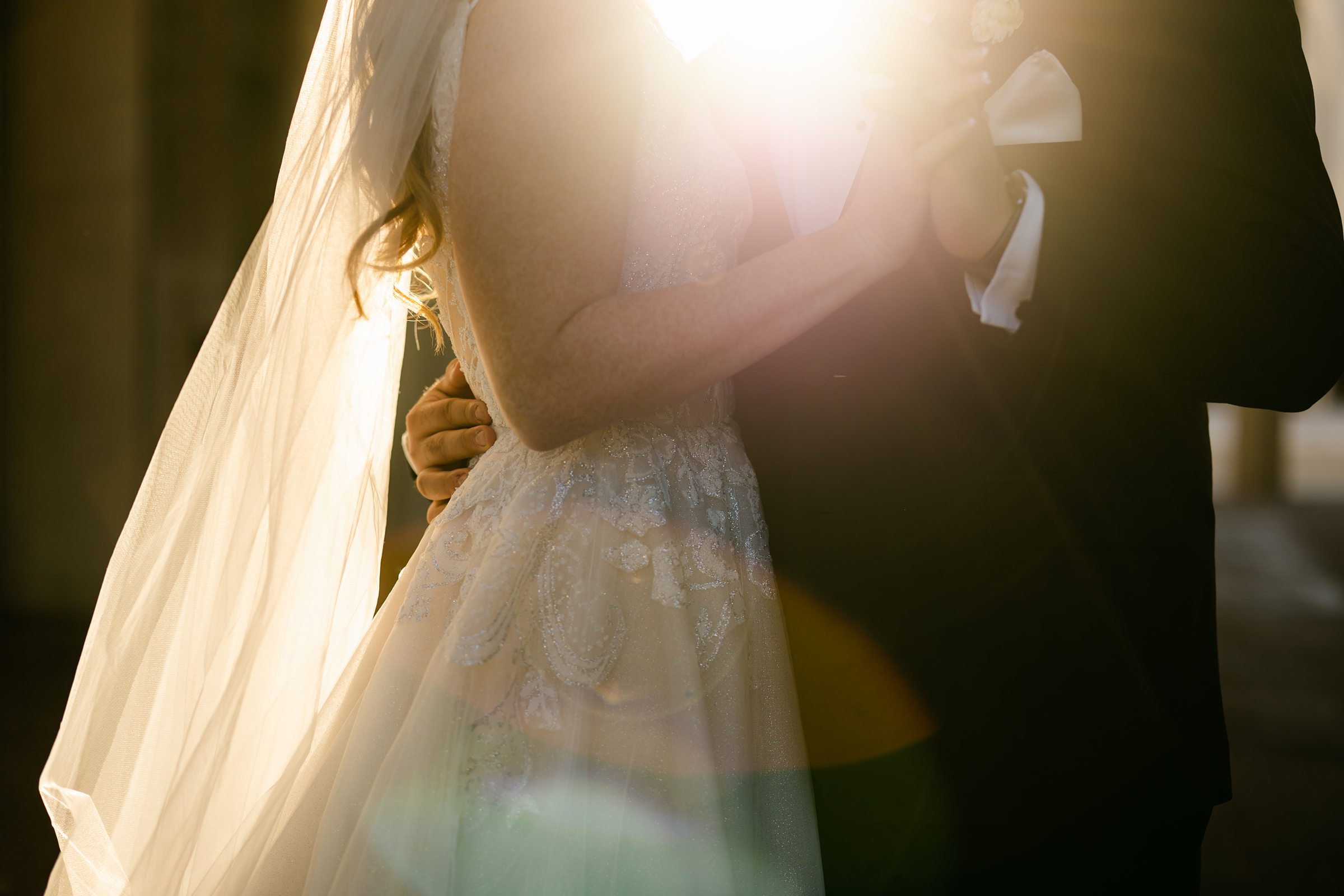 Bride and Groom snuggling with gorgeous sunlight by Michele Maloney Photography