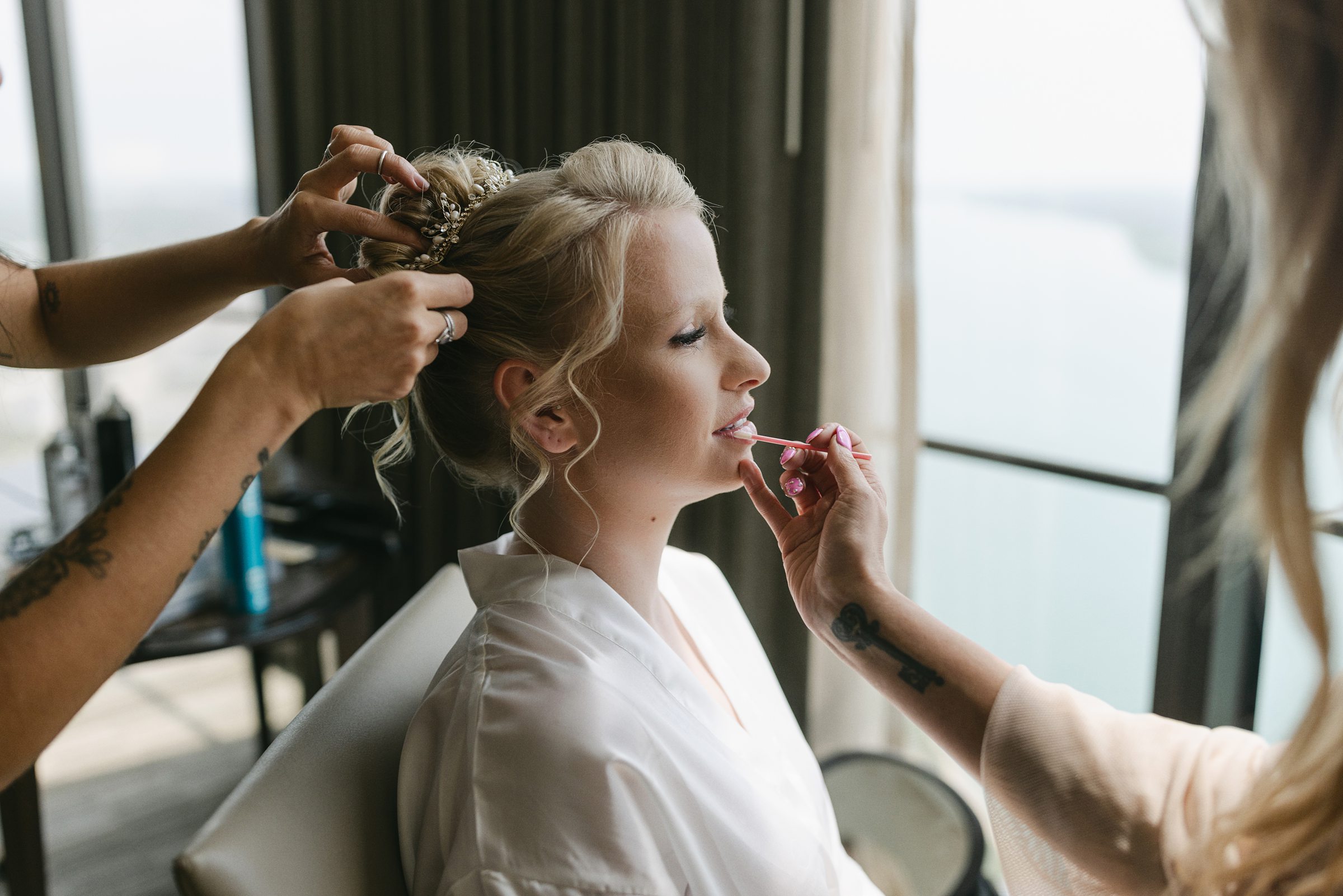 bride getting hair and makeup done at the Mariott in Detroit by Michele Maloney Photography