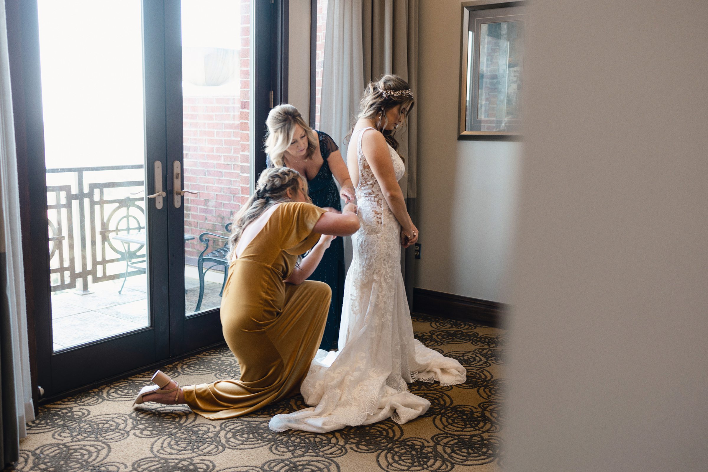 mom and sister getting bride dressed at Saint John's Resort by Michele Maloney Photography