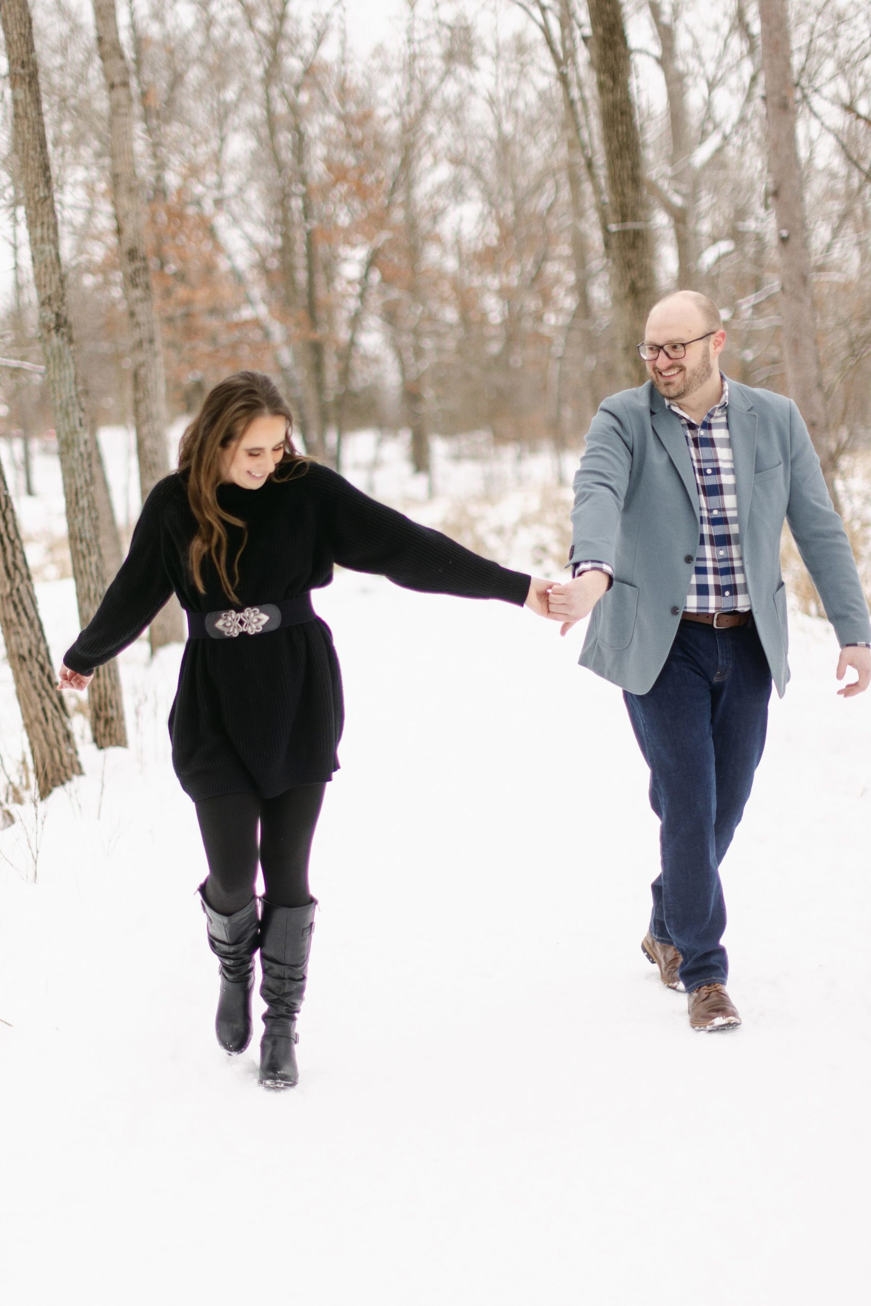 couple walking in the snow for their engagement session