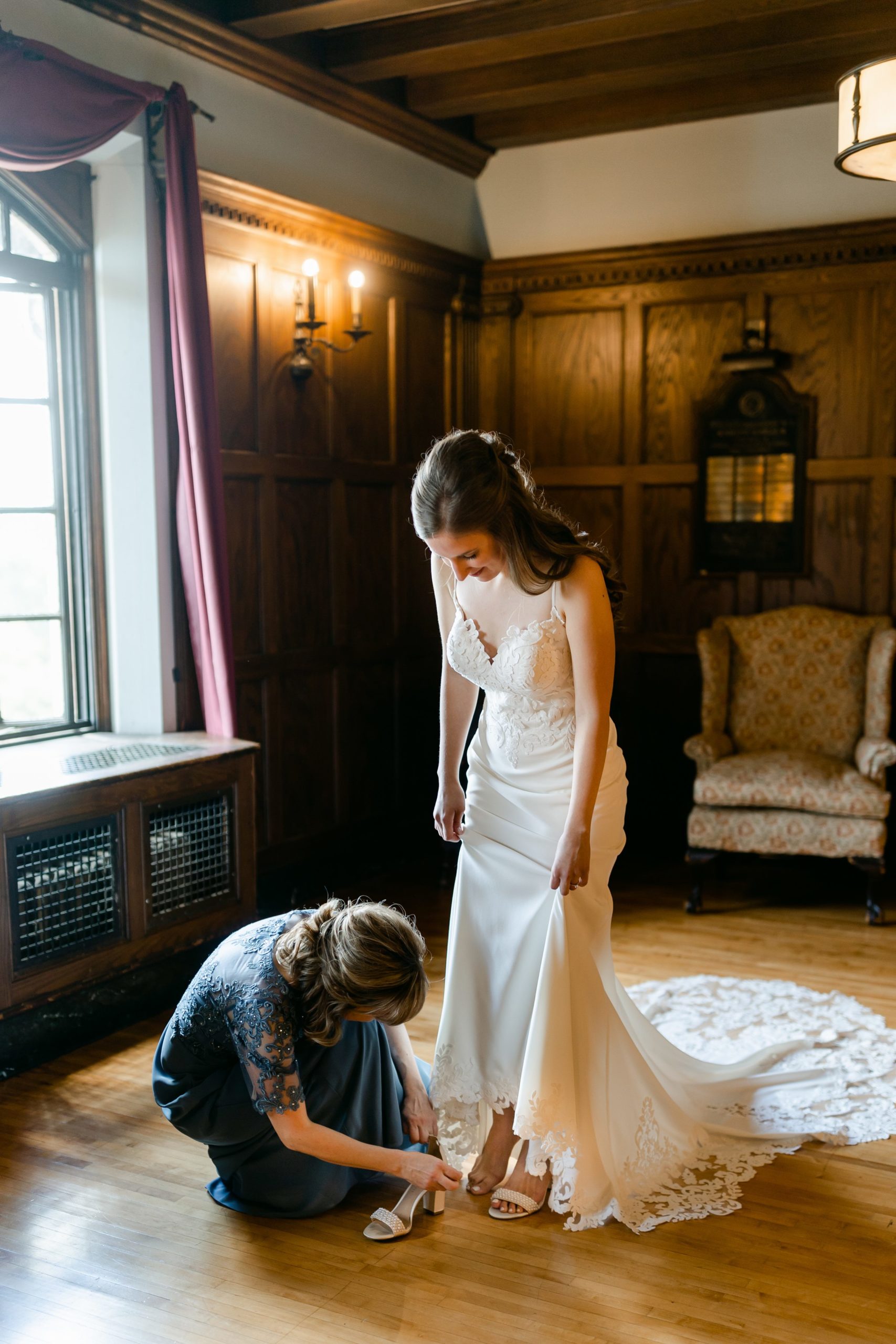 Bride getting shoes on at the Masonic Temple in Detroit by Michele Maloney Photography