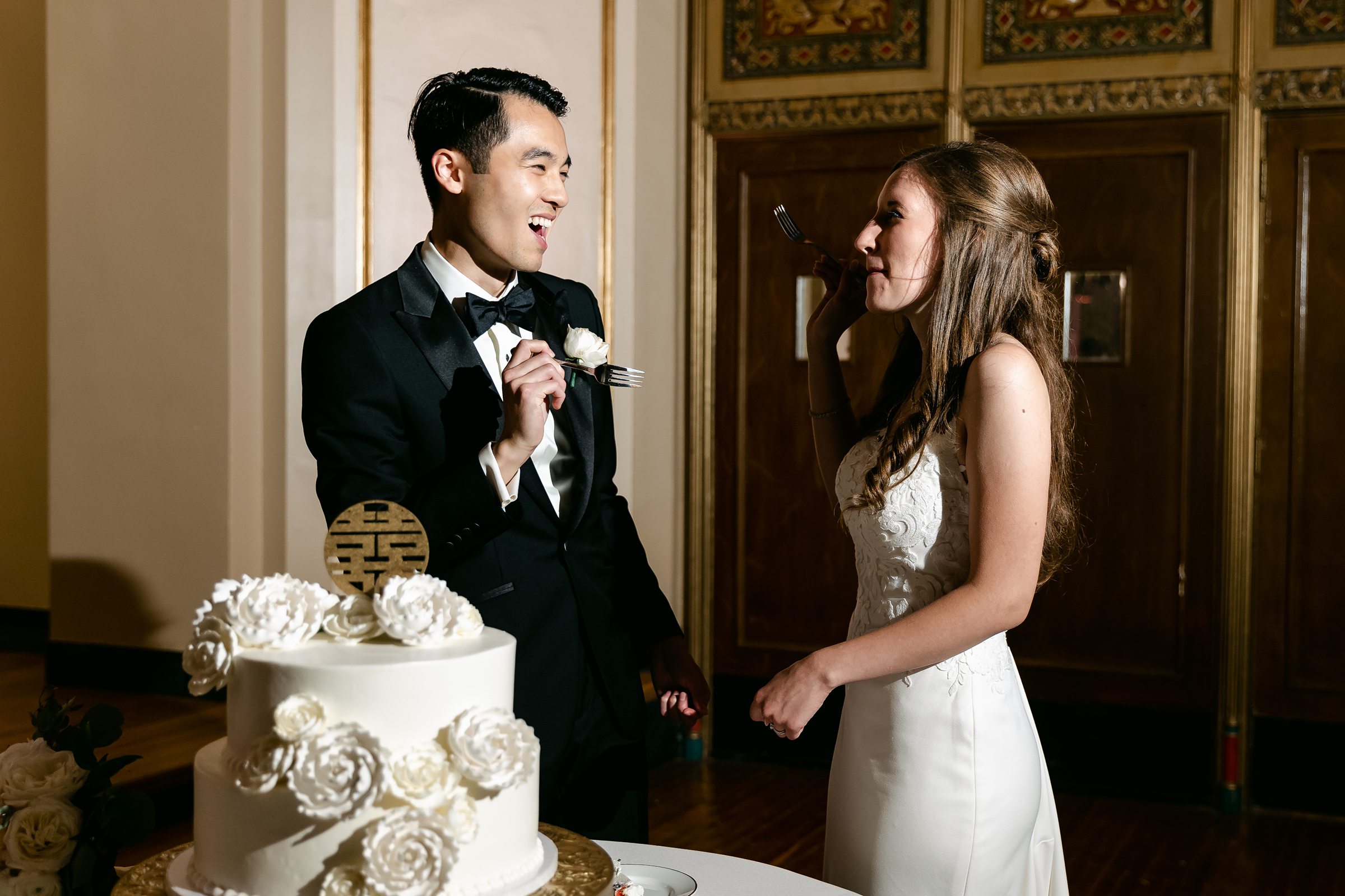 Bride and groom eating cake at the Masonic Temple in Detroit by Michele Maloney Photography