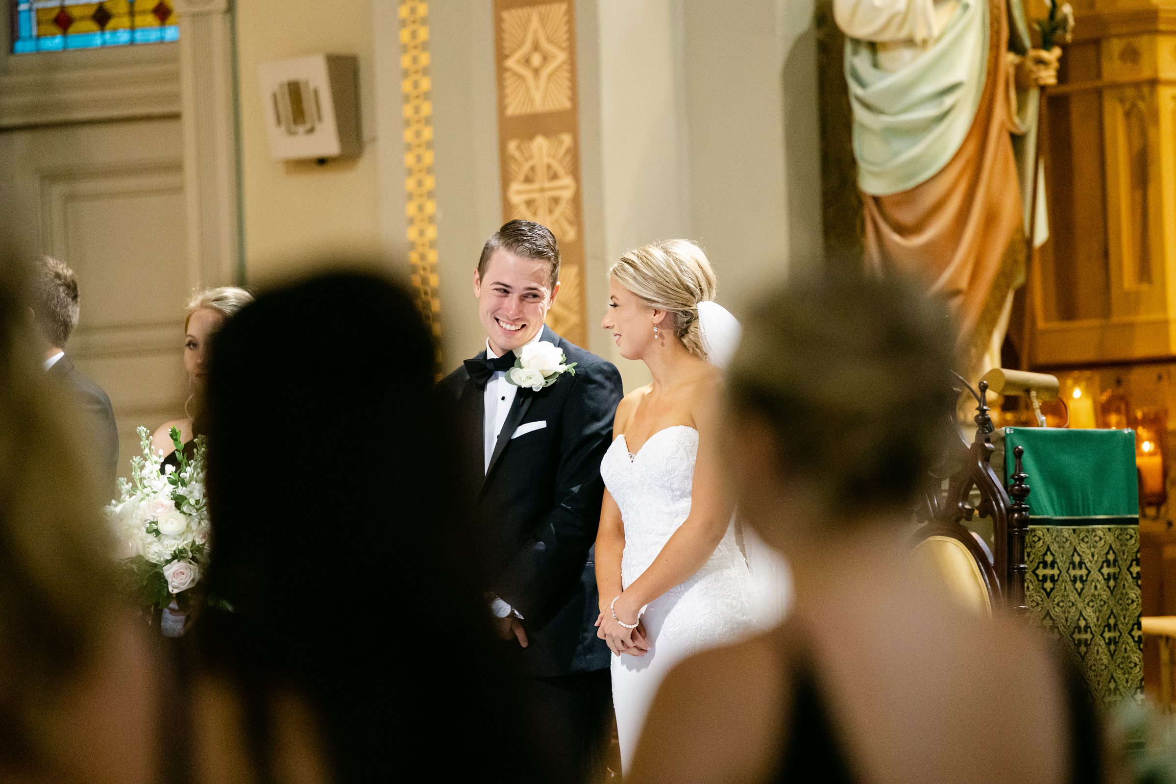 wedding couple steals a smile during mass at Old St Mary's in Detroit 