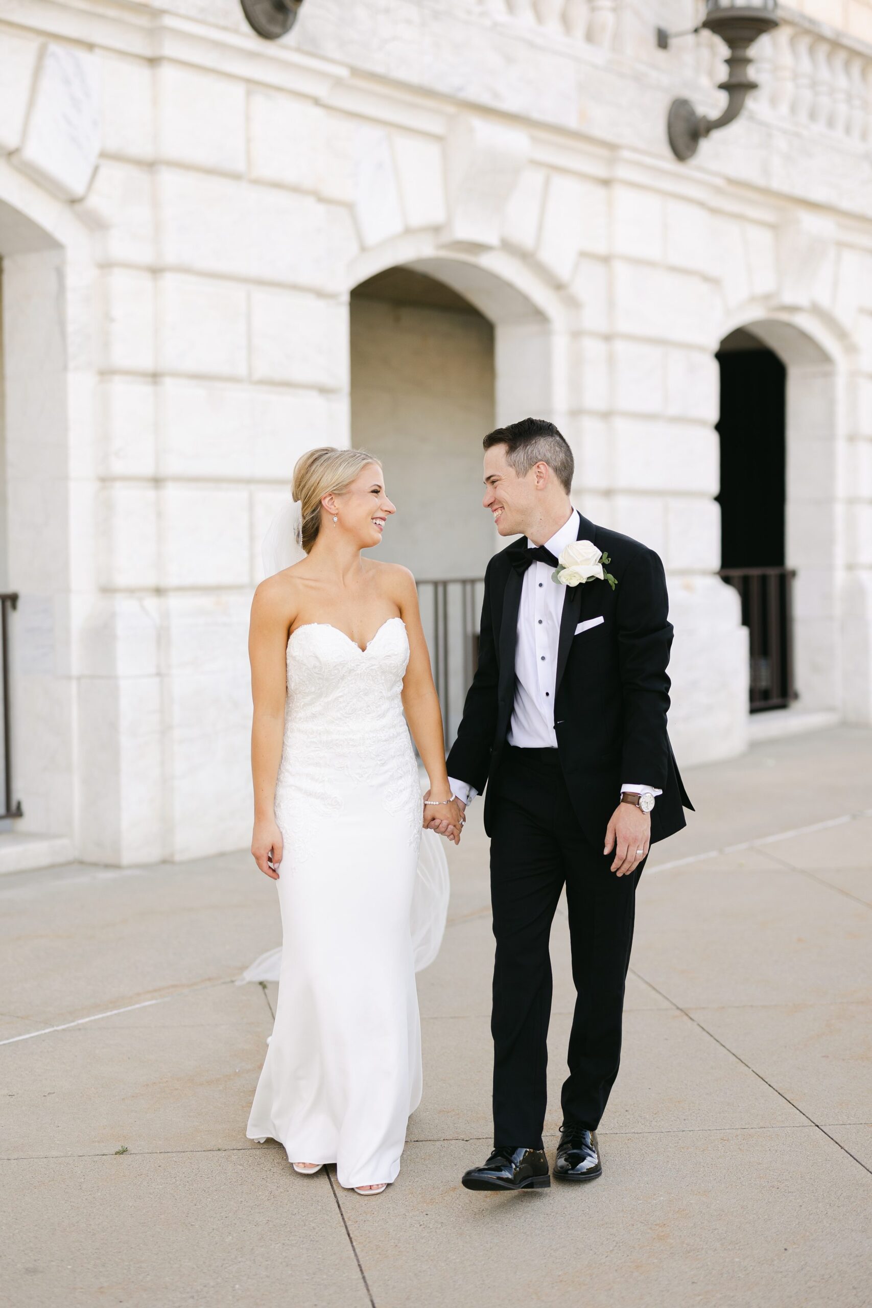 Bride and groom walking hand in hand at the DIA before their reception at the Colony Club in Detroit by Michele Maloney Photography