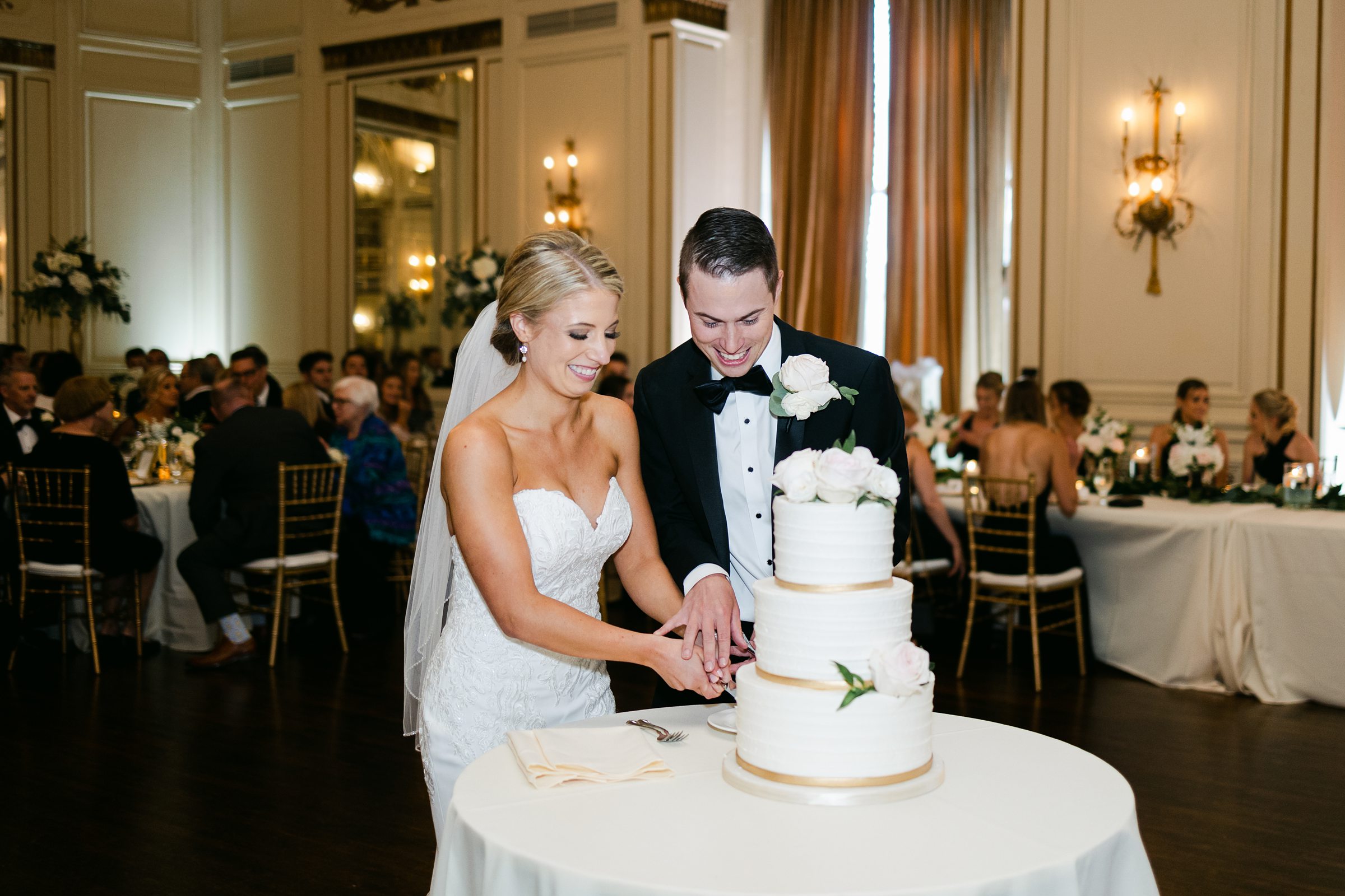 Wedding couple cutting the cake at indoor wedding reception