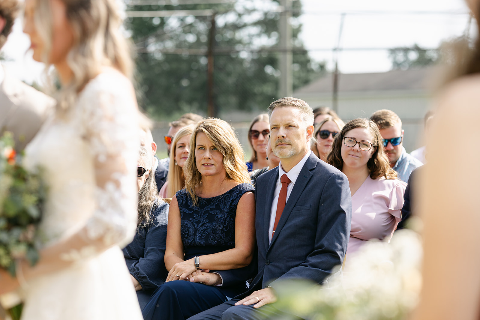 Couple exchanging vows surrounded by family and friends at their September wedding in Michigan.