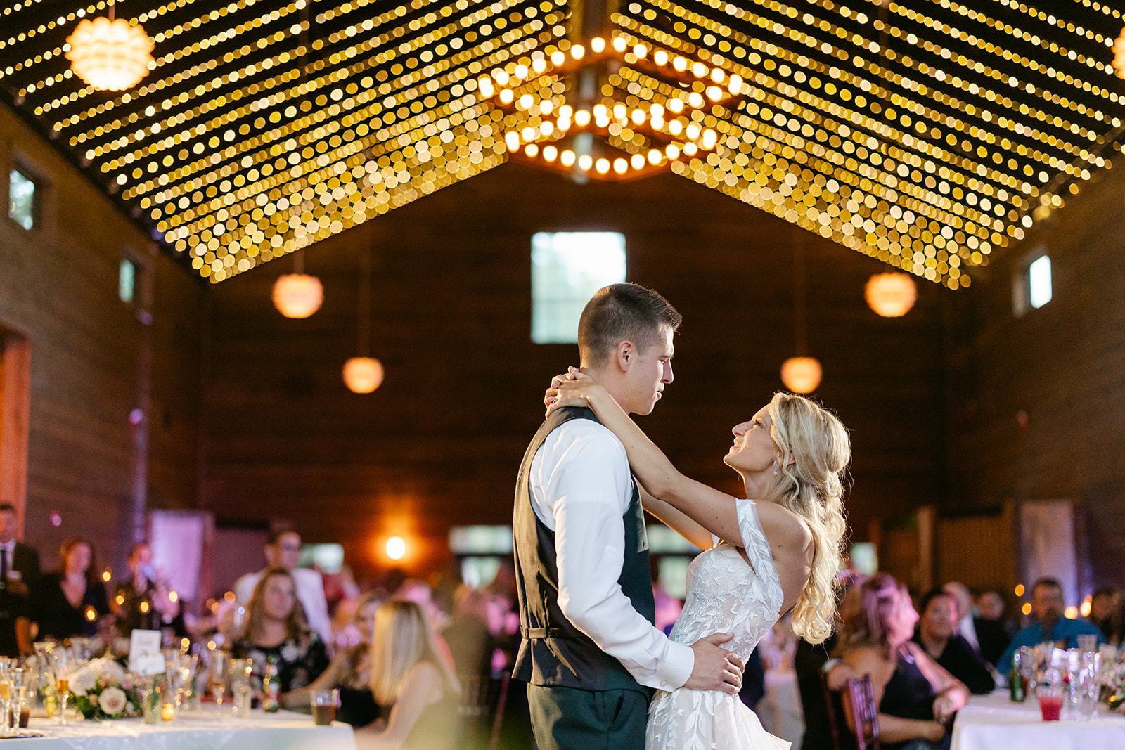 First dance under string lights at Tandale Nature Barn reception.