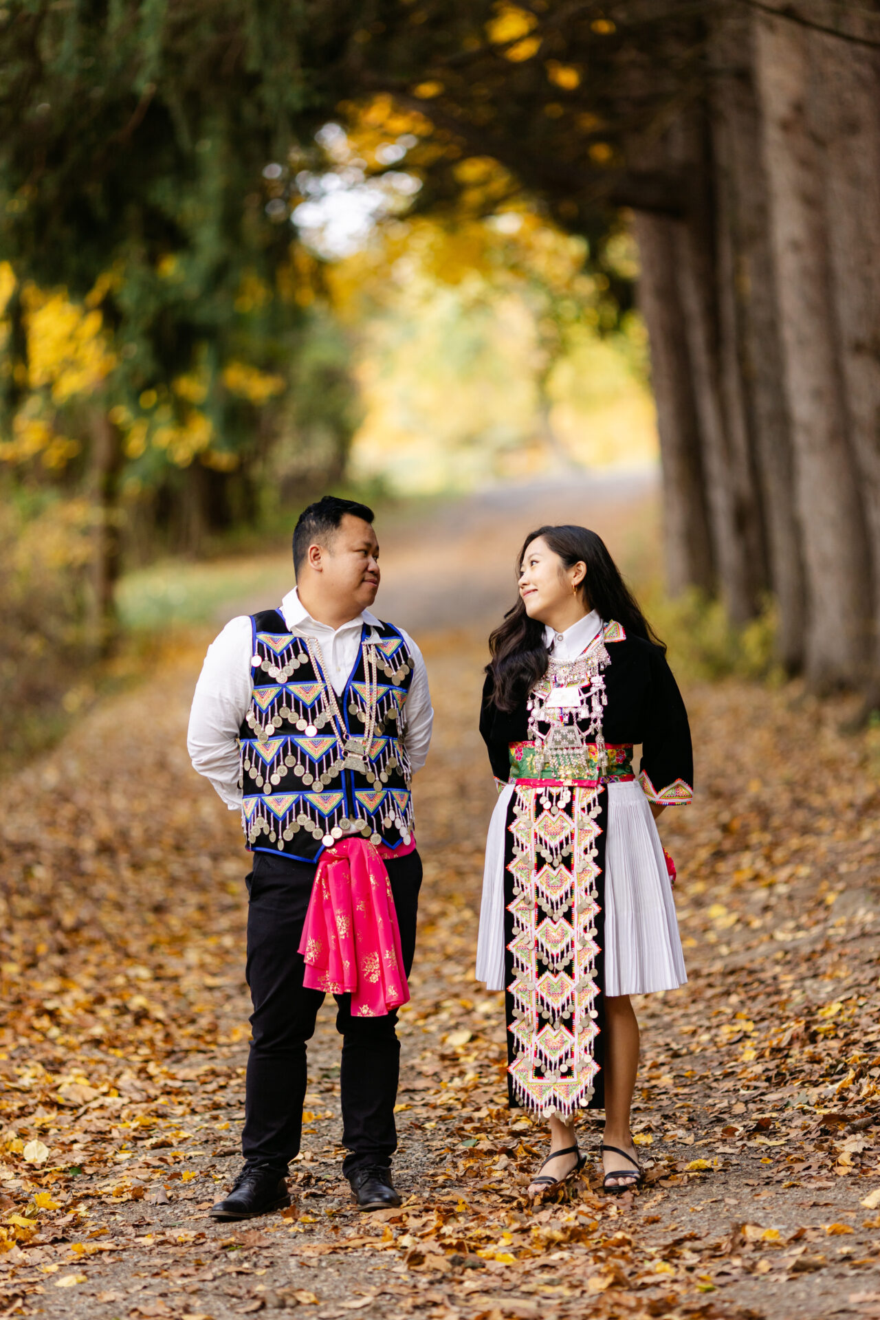 Couple standing beneath tall autumn trees during their Fall Session at Stoney Creek.