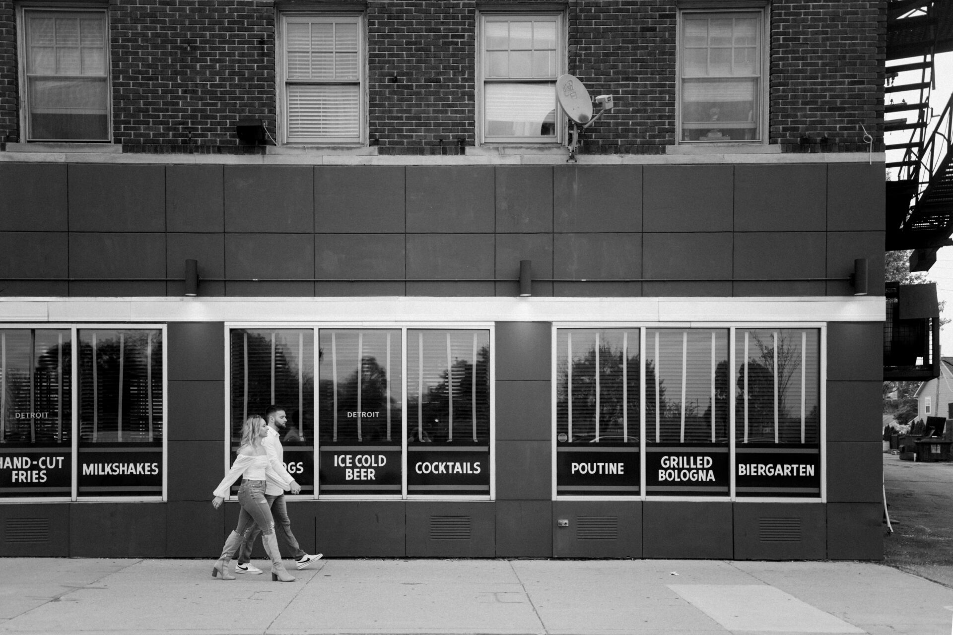 Couple walking near the Mercury Bar at their engagement session 